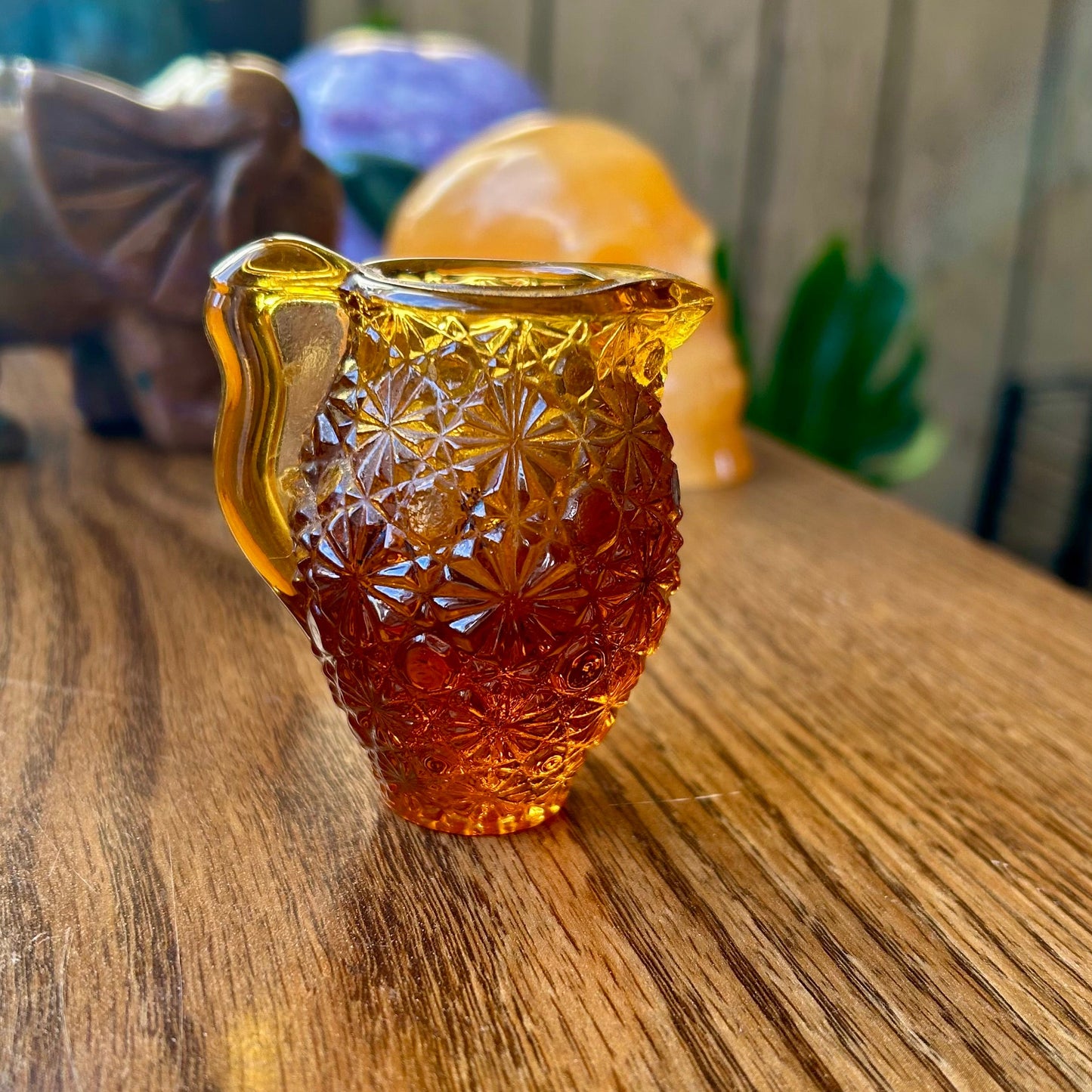 Amber glass pitcher with star patterns on a wooden surface