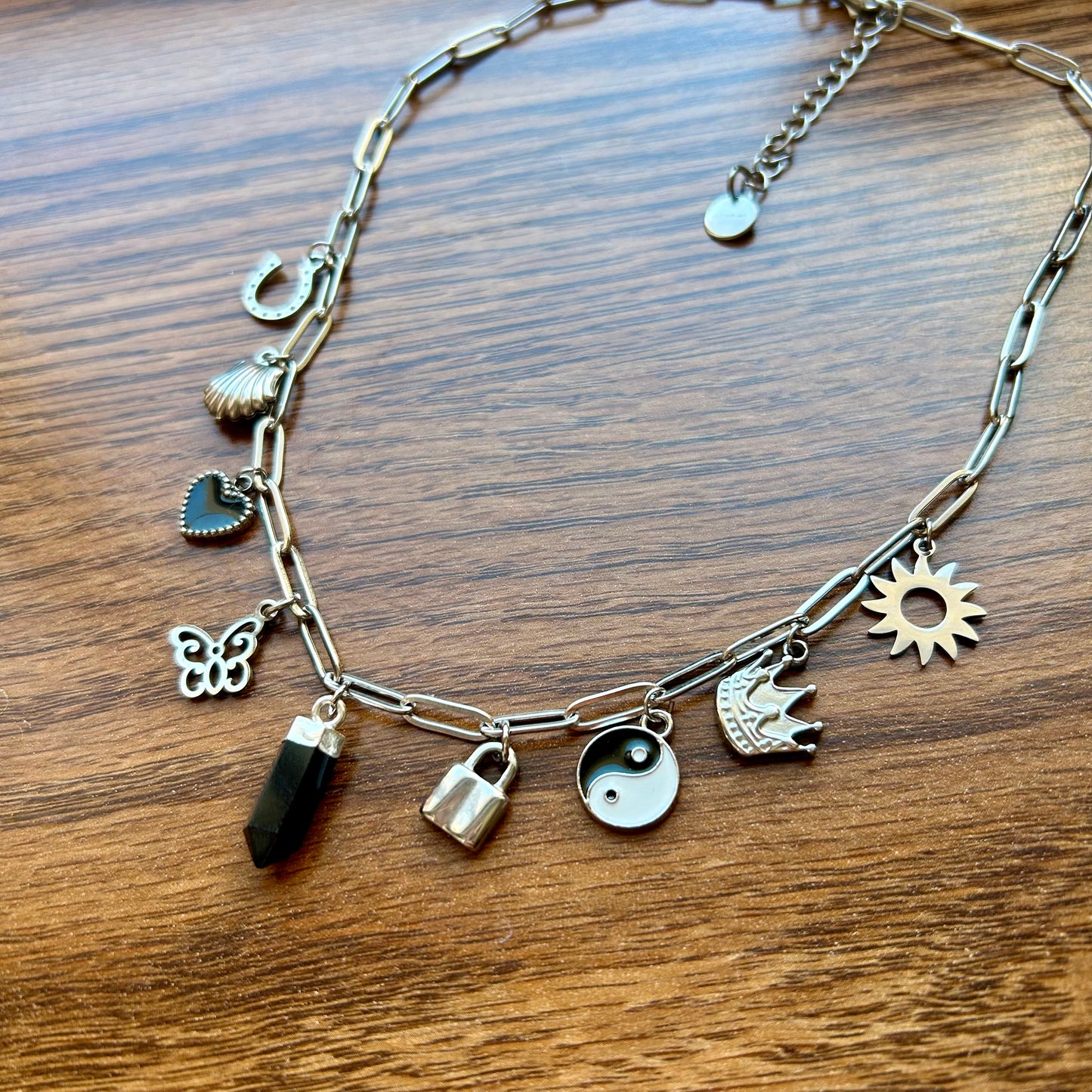 Necklace with various charms on a wooden surface
