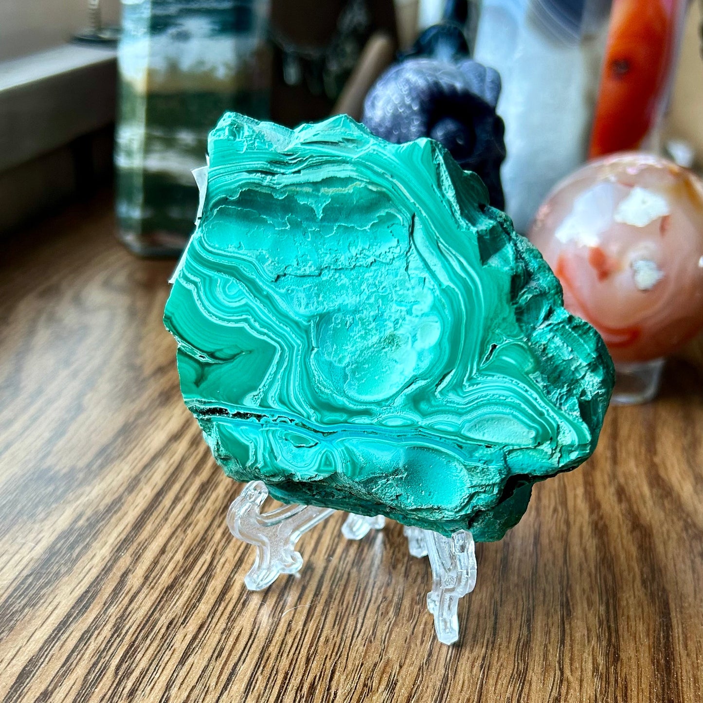 Green mineral specimen on a wooden surface with blurred background