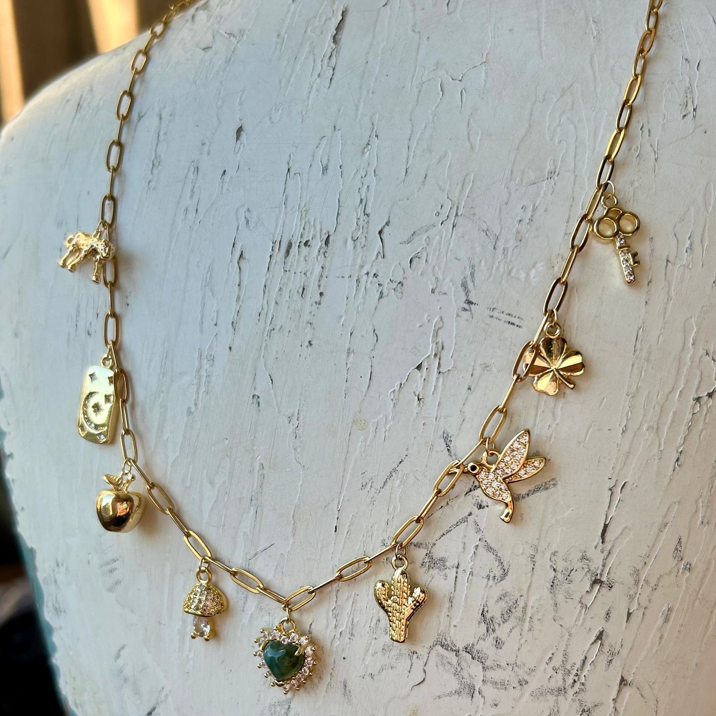 Gold necklace with charms on a mannequin head