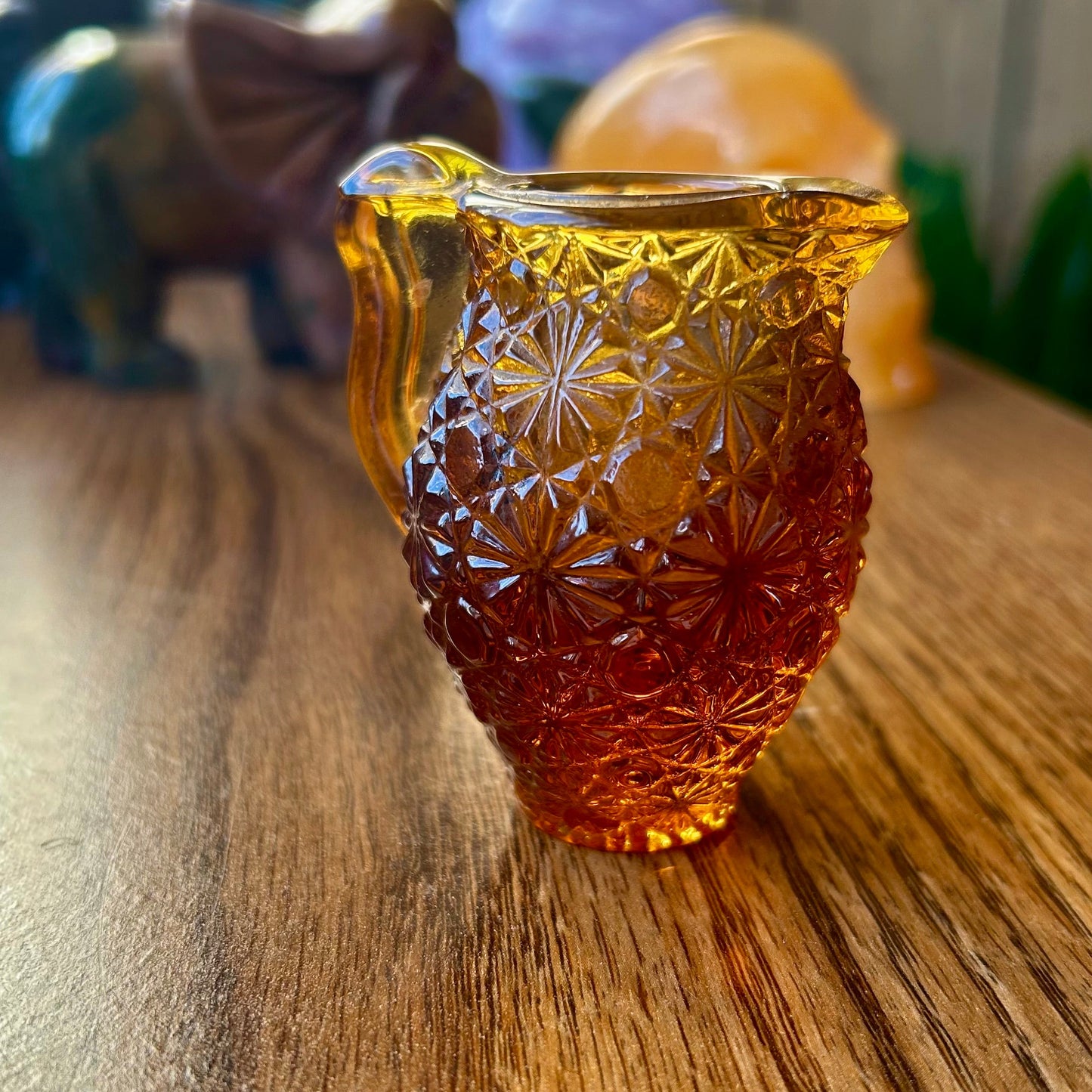 Decorative amber glass vase on a wooden surface with blurred background