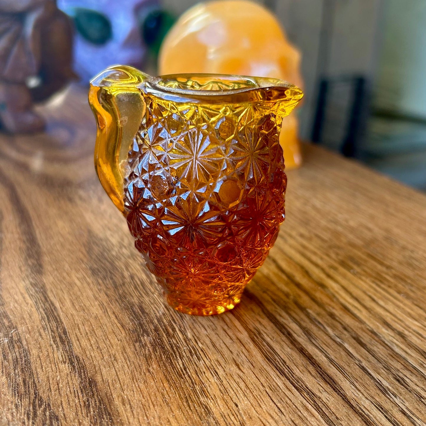 Amber glass owl-shaped container on a wooden surface