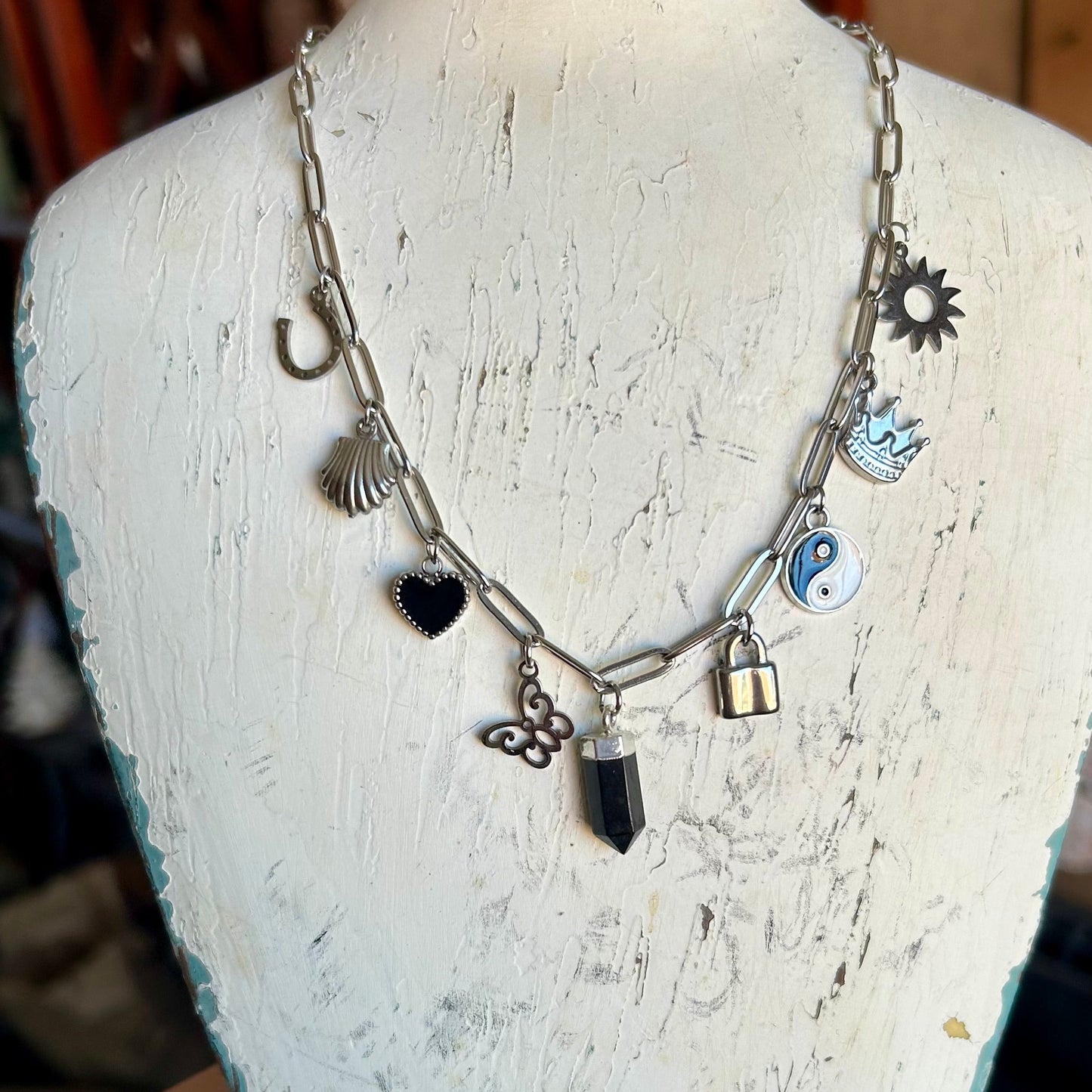 Necklace with various charms on a mannequin bust