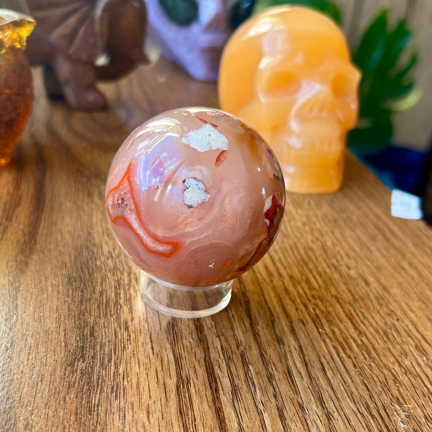 Marbled stone sphere on a wooden surface with other decorative items in the background