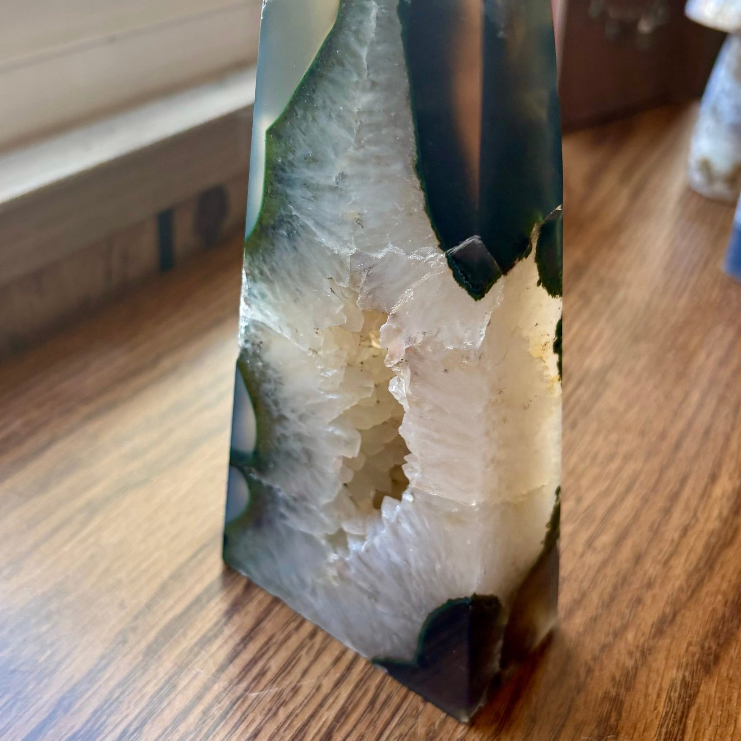 Geode crystal on a wooden surface with a window in the background