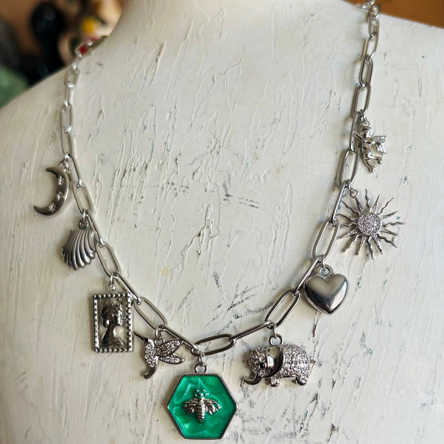 Necklace with various charms on a mannequin bust