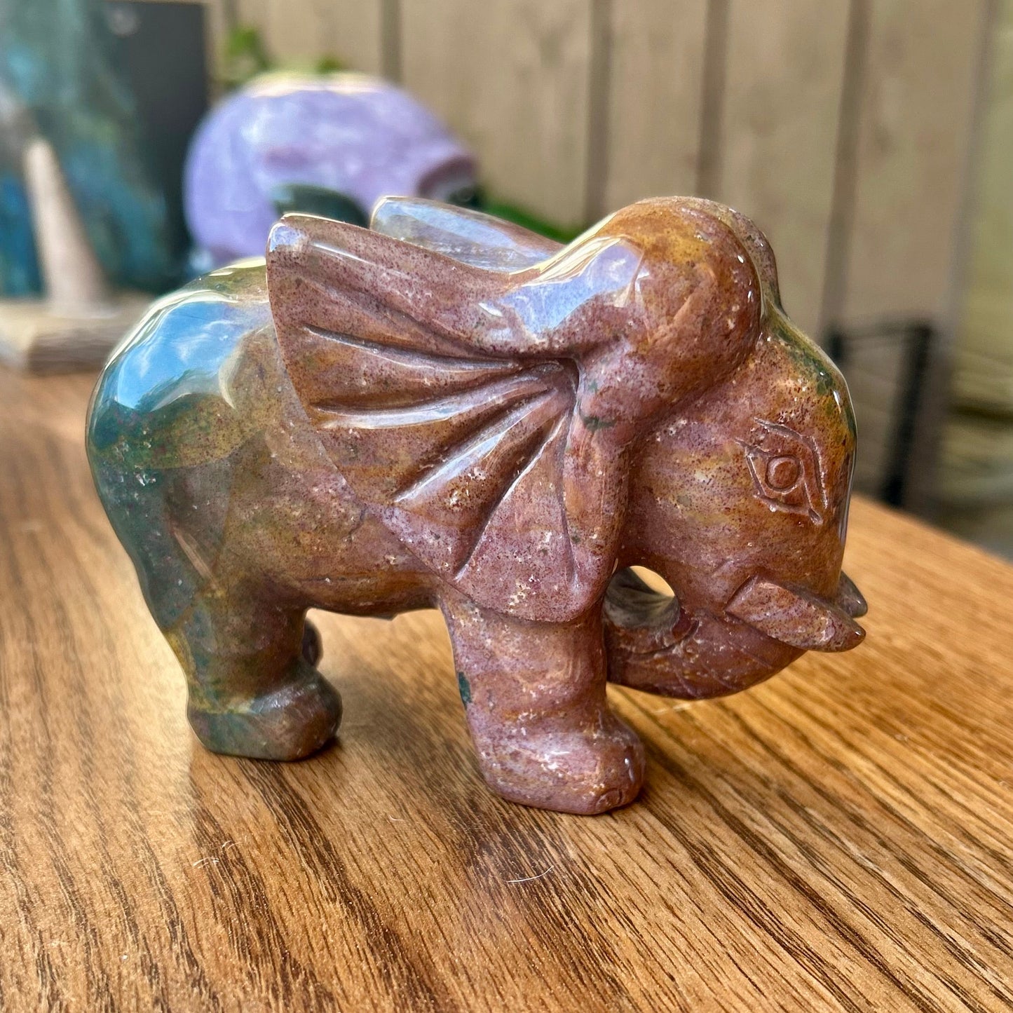 Carved stone elephant figurine on a wooden surface
