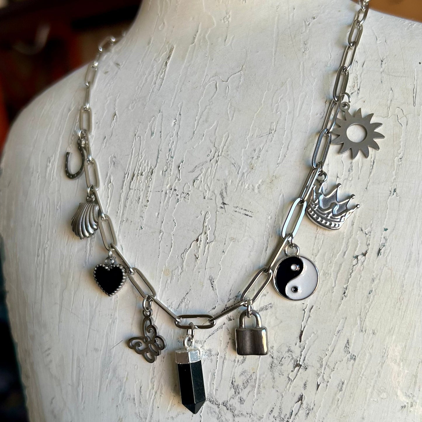 Necklace with various charms on a mannequin bust
