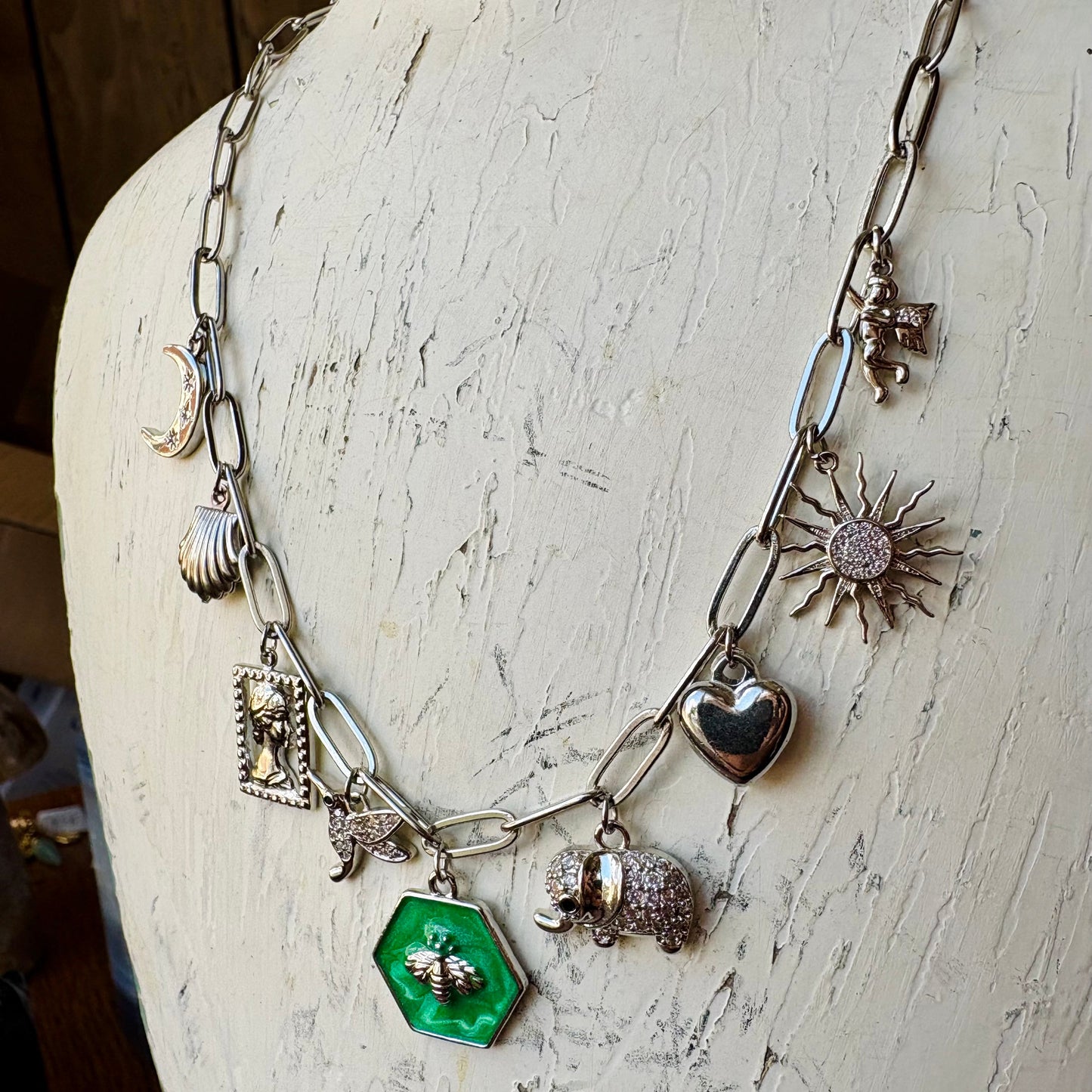 Necklace with various charms on a textured white surface
