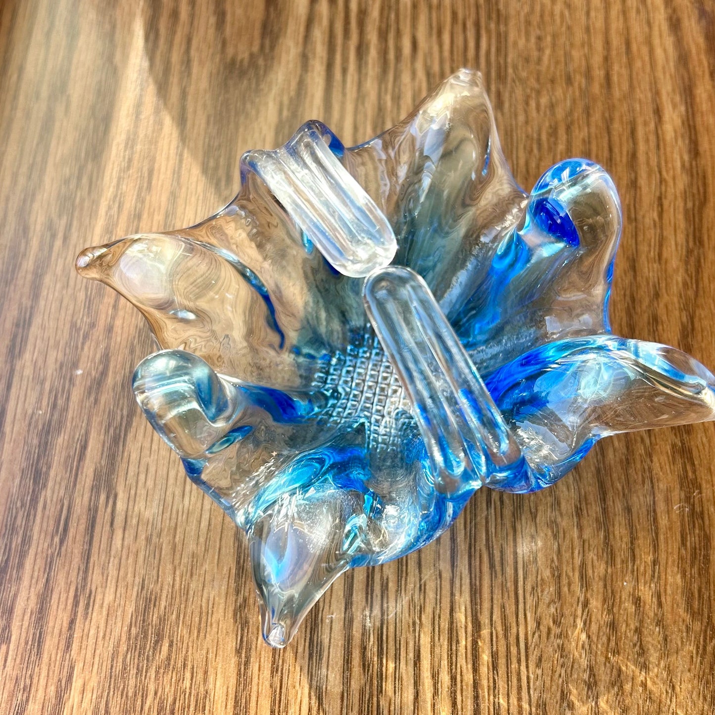Blue glass sculpture on a wooden surface