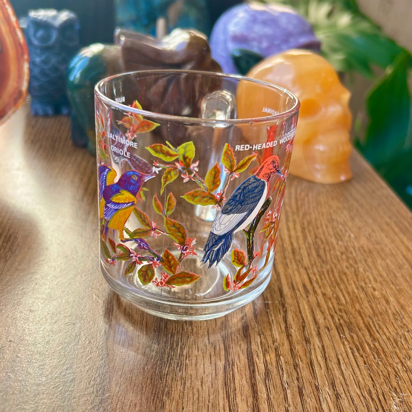 Decorative glass with colorful designs on a wooden surface