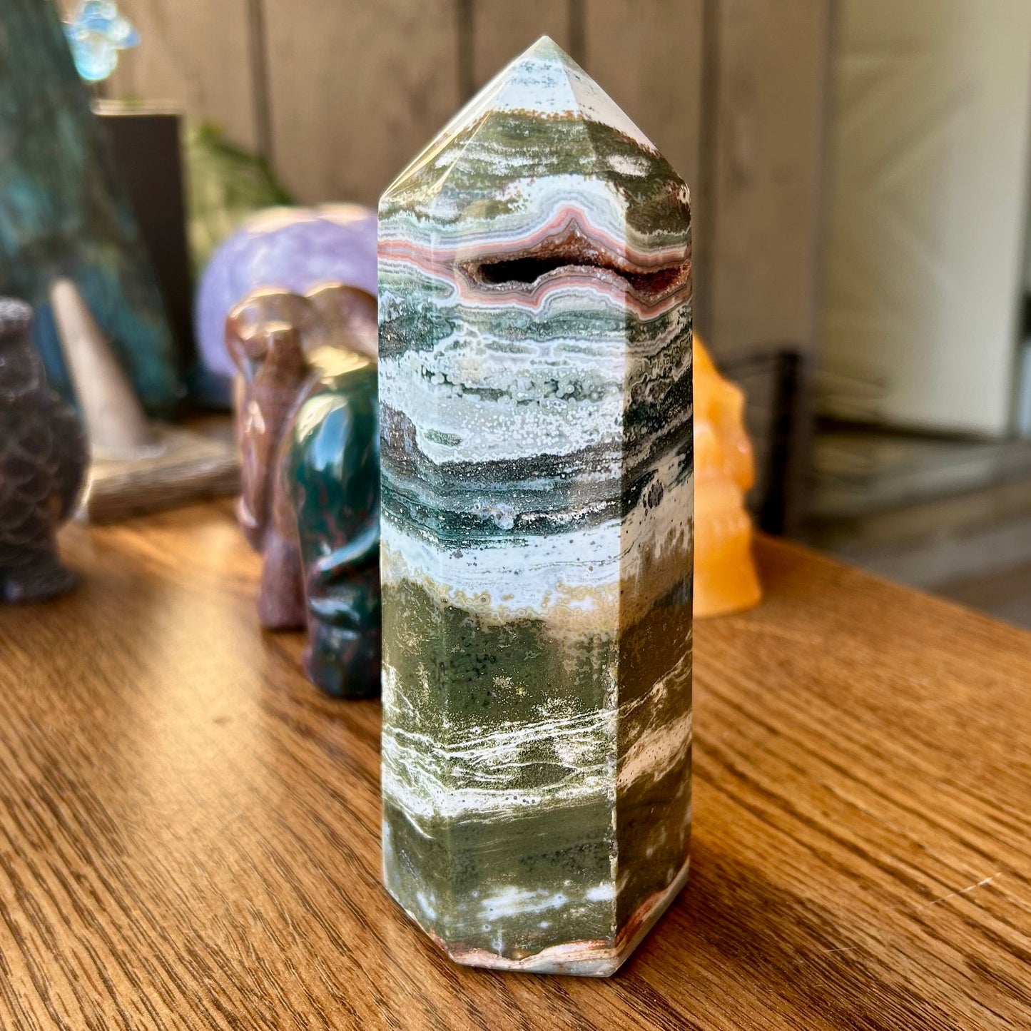 Multicolored crystal tower on a wooden surface with blurred background