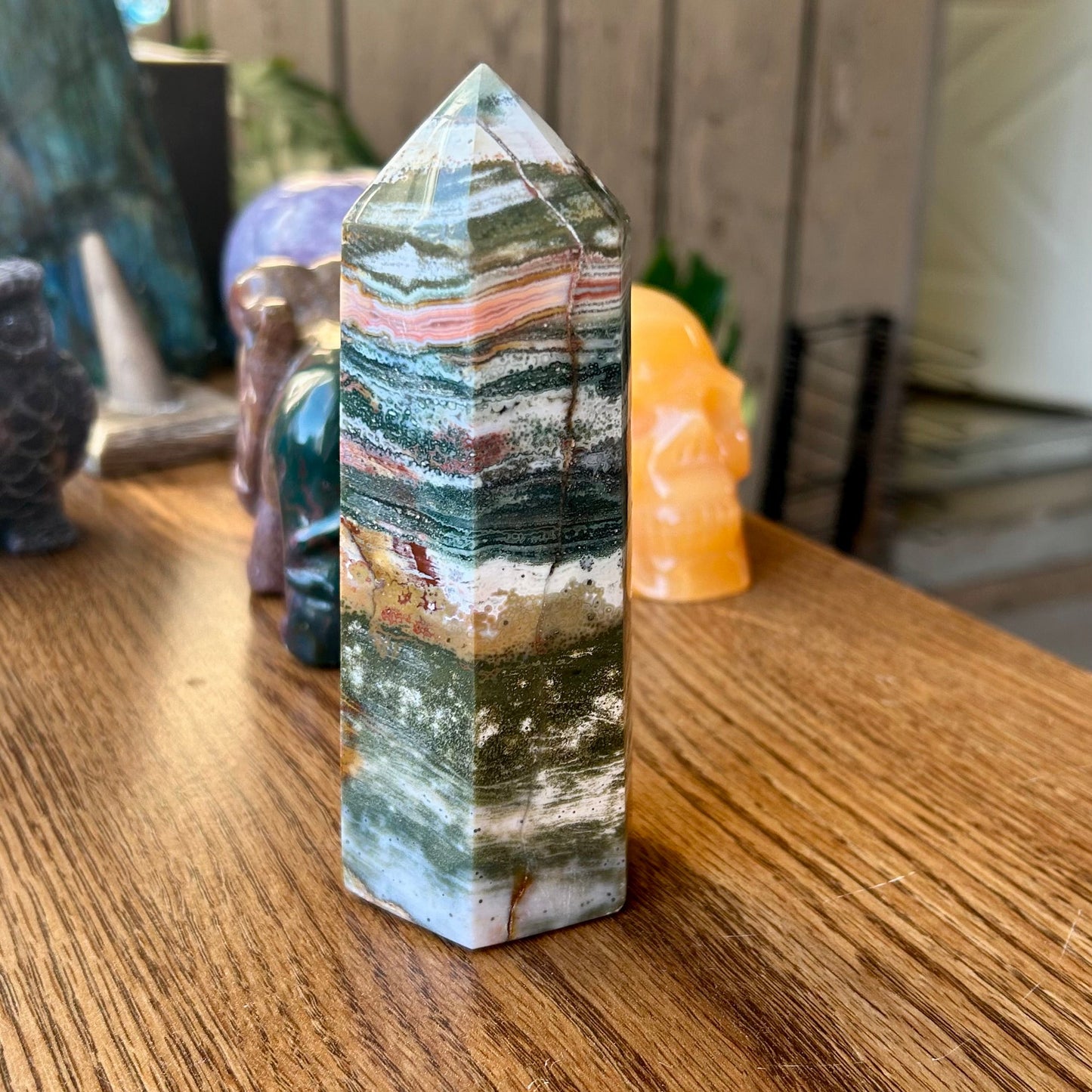 Multicolored crystal tower on a wooden surface with blurred background