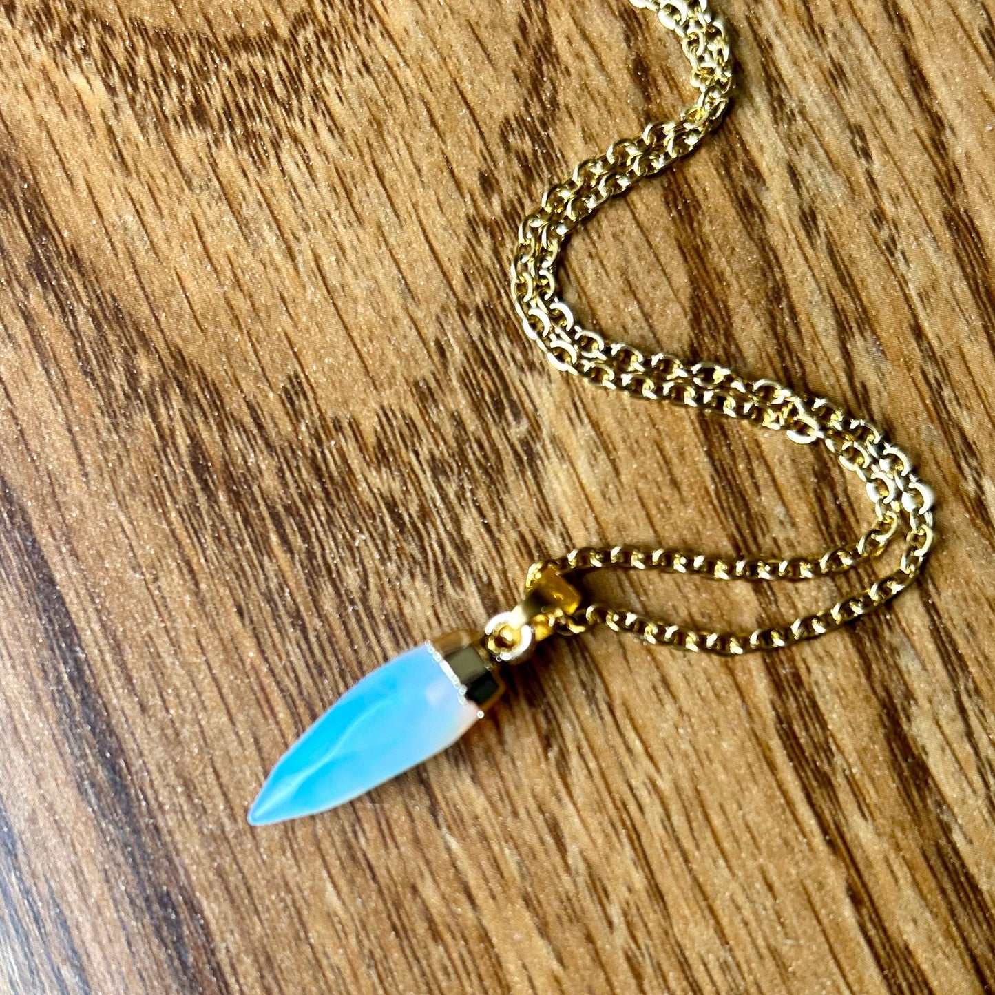 Necklace with a blue pendant on a wooden surface