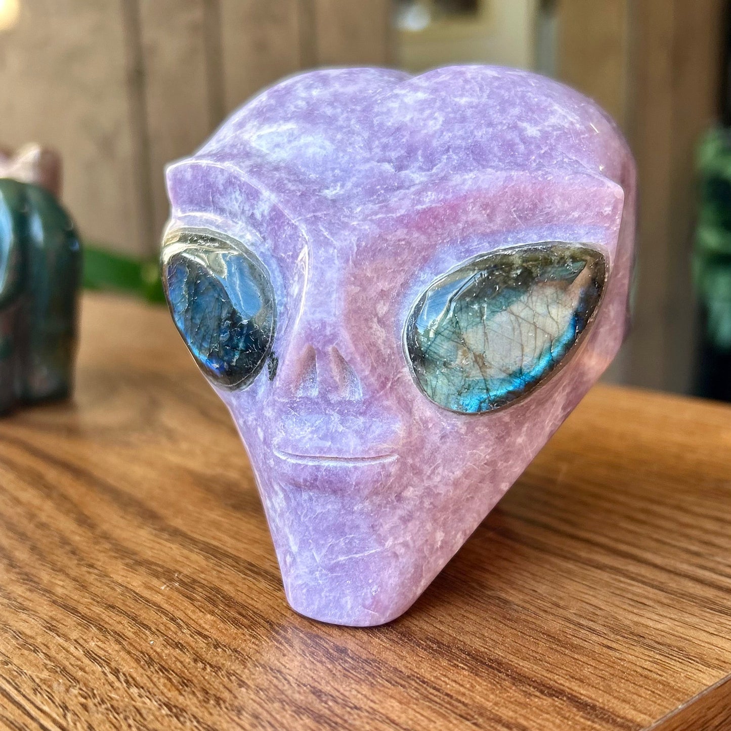 Crystal alien head on a wooden surface with a blurred background