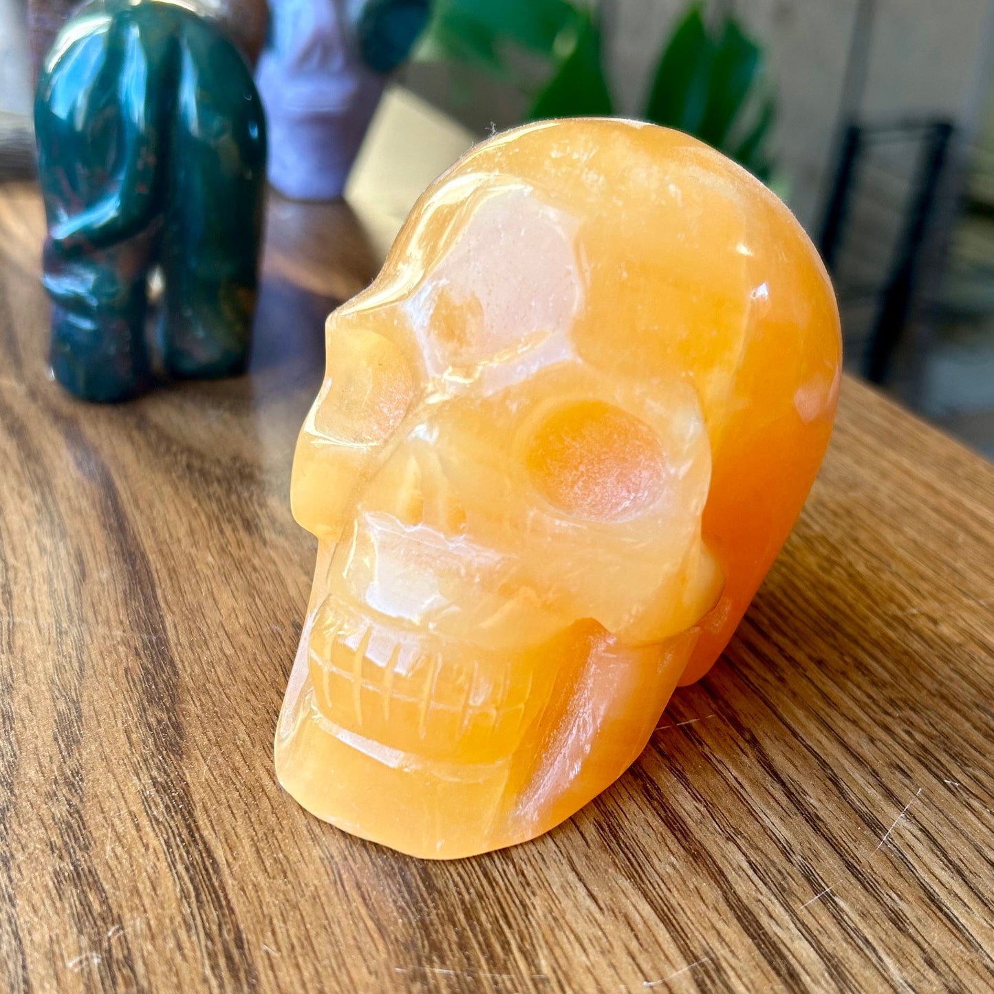 Orange crystal skull on a wooden surface with blurred background
