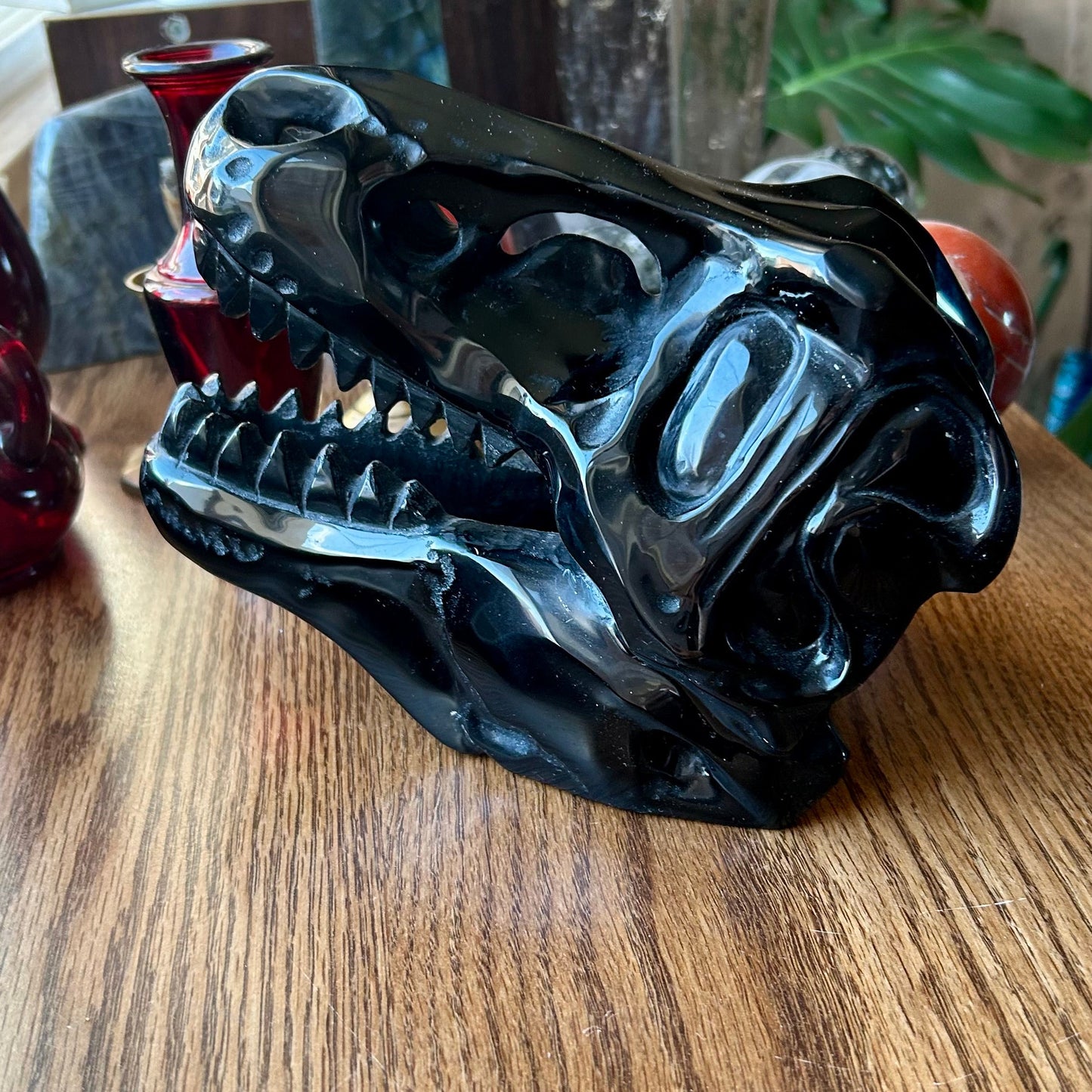 Black dragon head sculpture on a wooden surface with a blurred background