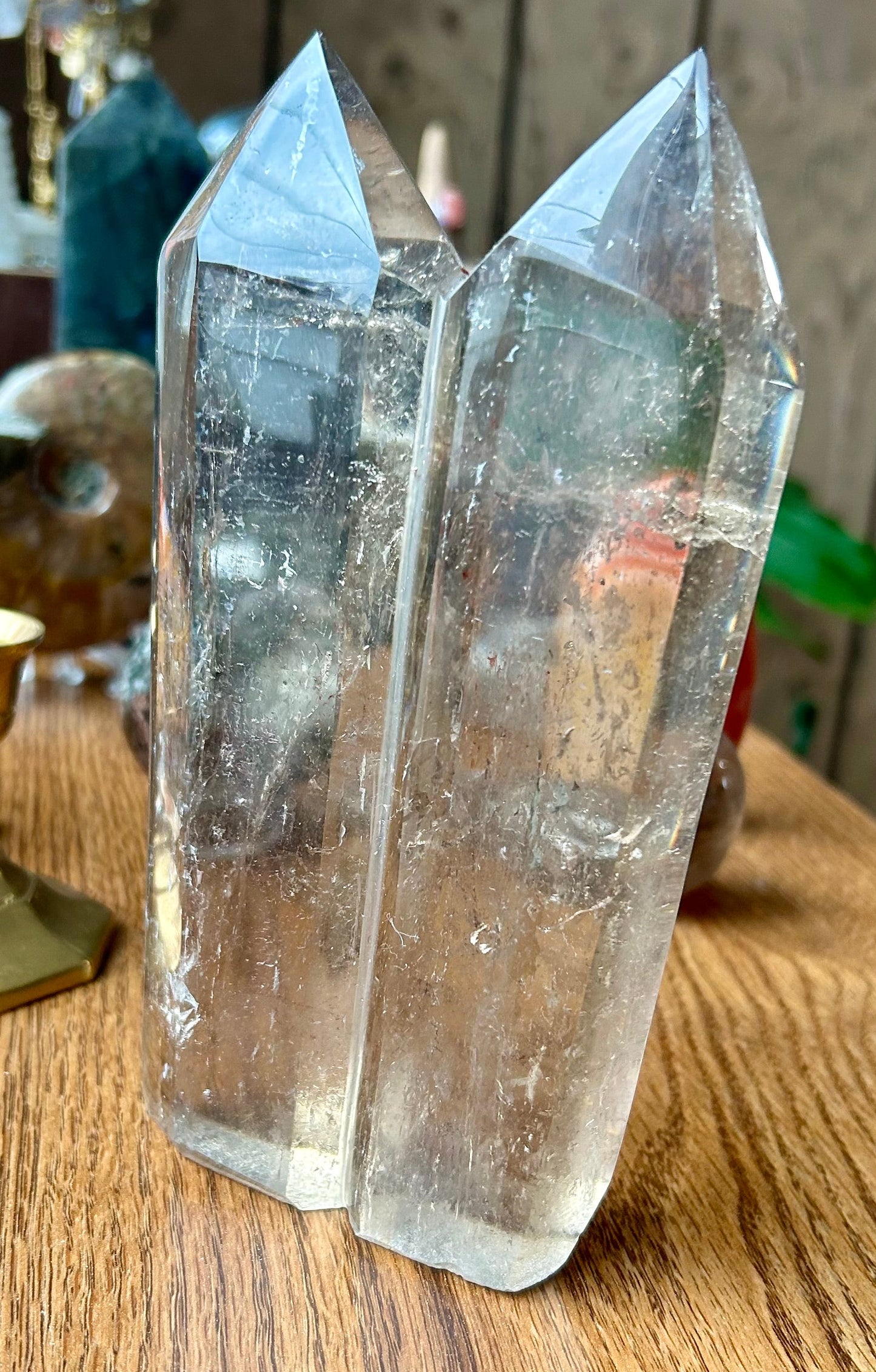 Two crystal points on a wooden surface with a blurred background