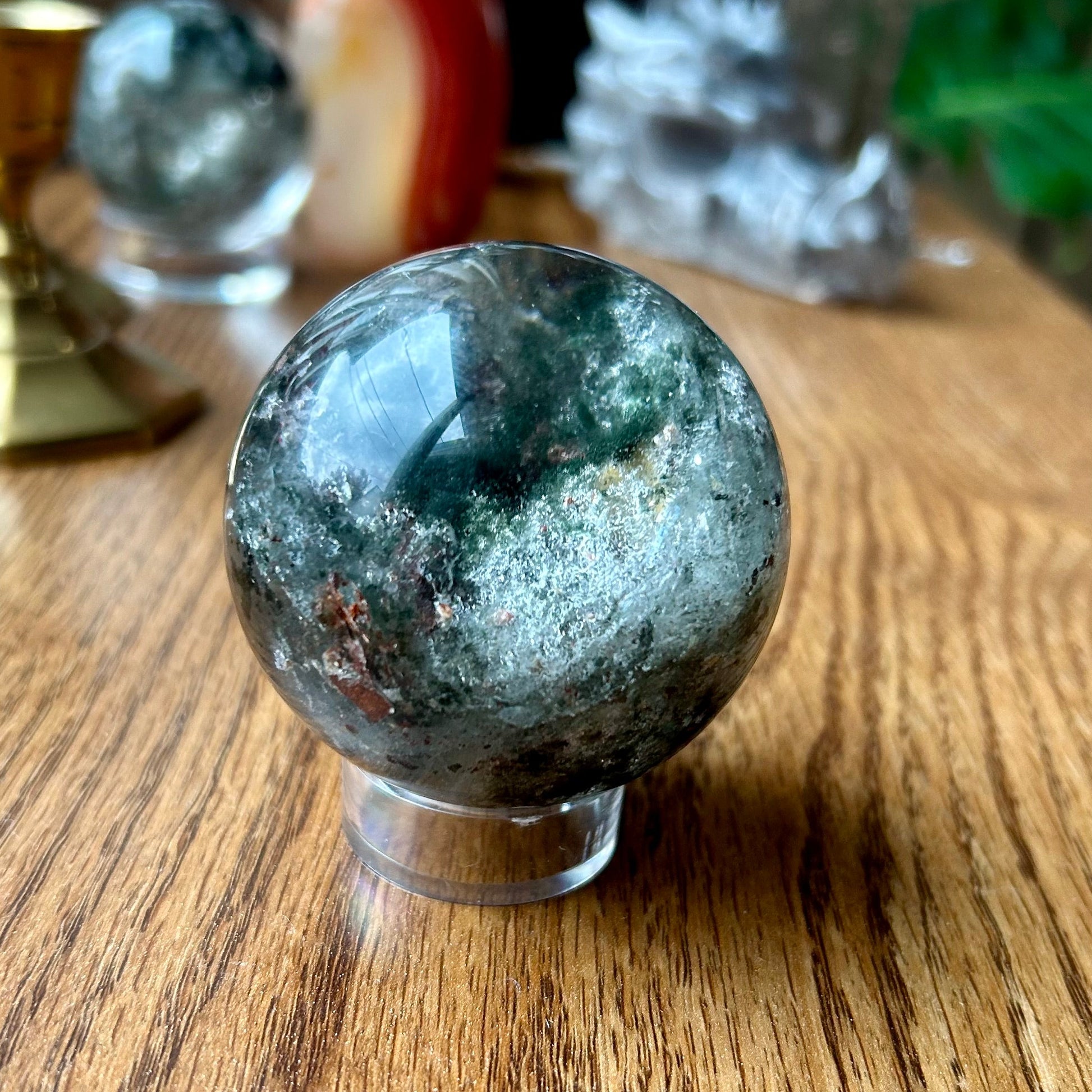 Green crystal sphere on a wooden surface with blurred background