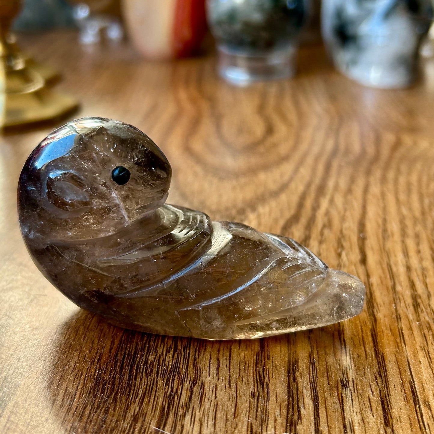 Decorative stone bird on a wooden surface with blurred background