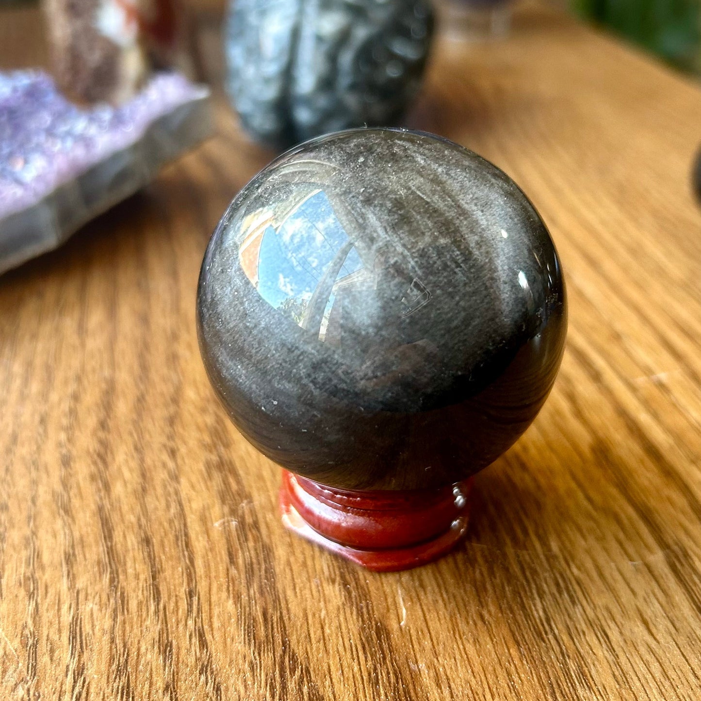 Black crystal ball on a wooden surface with blurred background