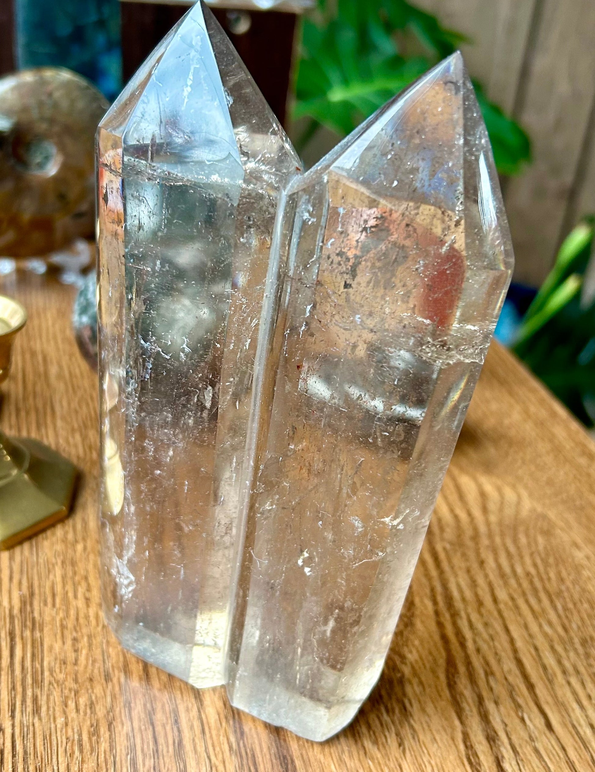 Two crystal formations on a wooden surface with a blurred background
