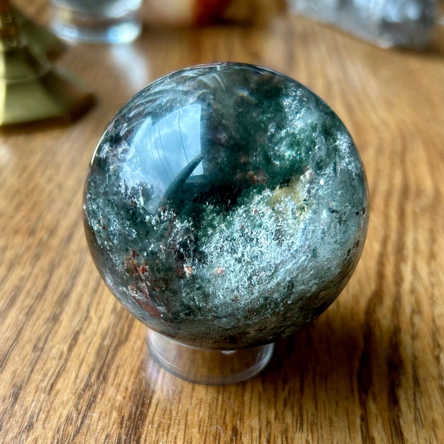 Green crystal ball on a wooden surface