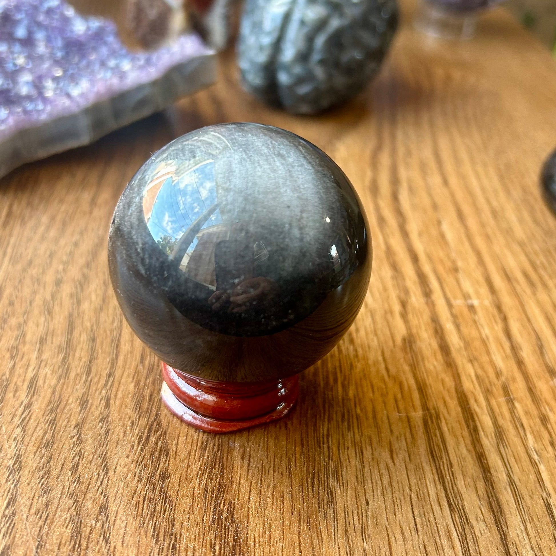 Black crystal ball on a wooden surface with blurred background