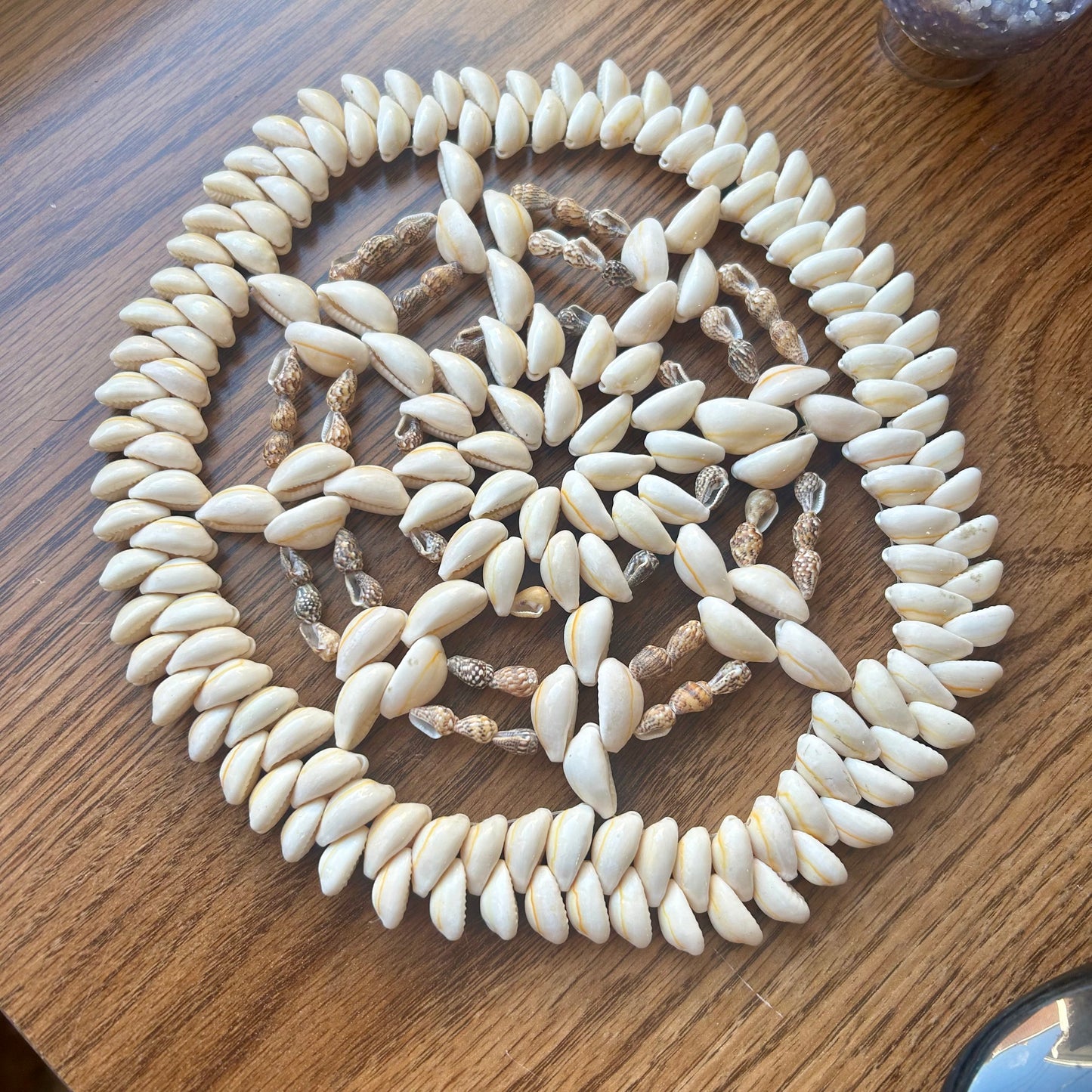 Necklace made of white shell beads on a wooden surface