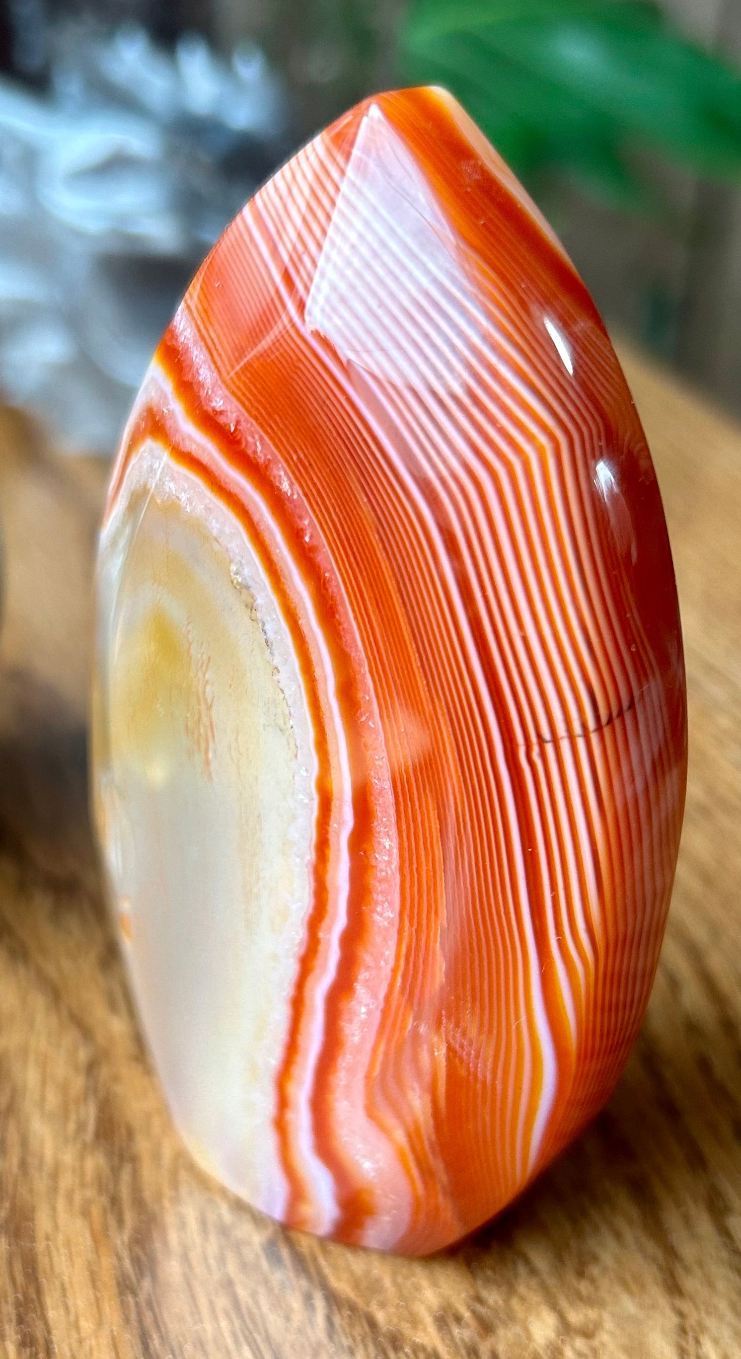 Agate stone with orange and white patterns on a wooden surface