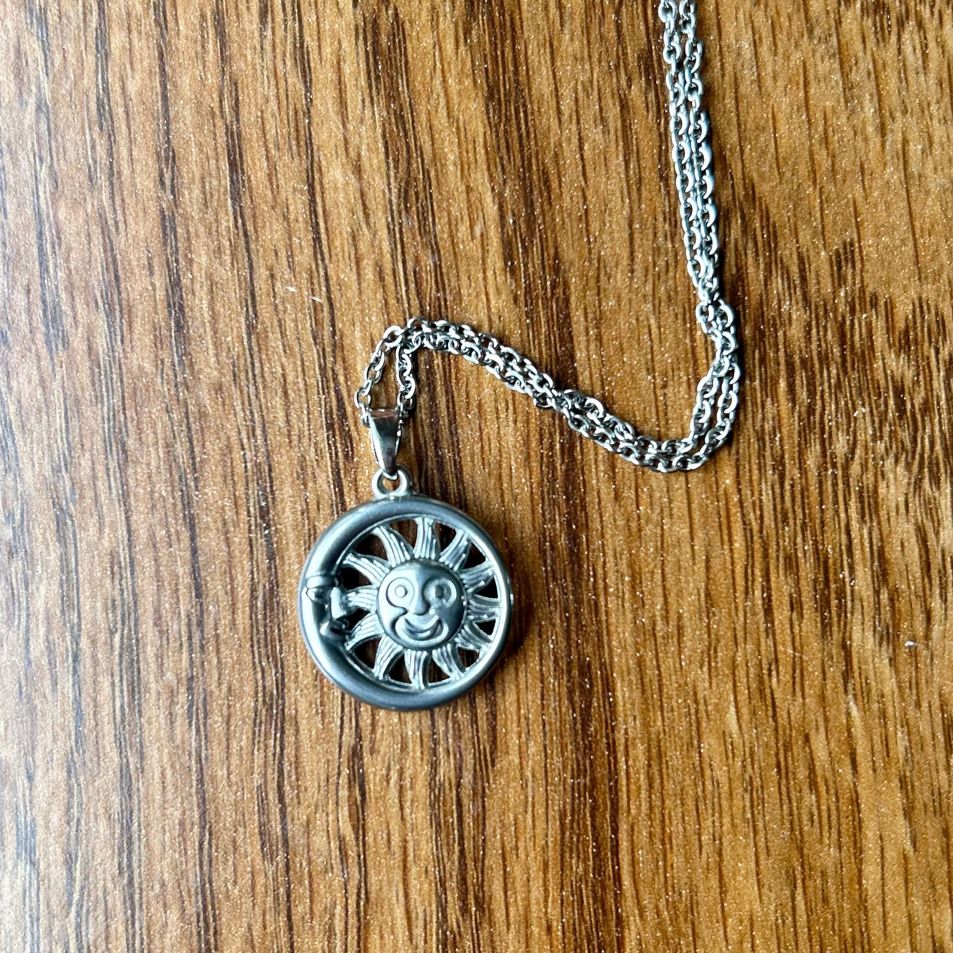 Silver necklace with a round pendant on a wooden surface