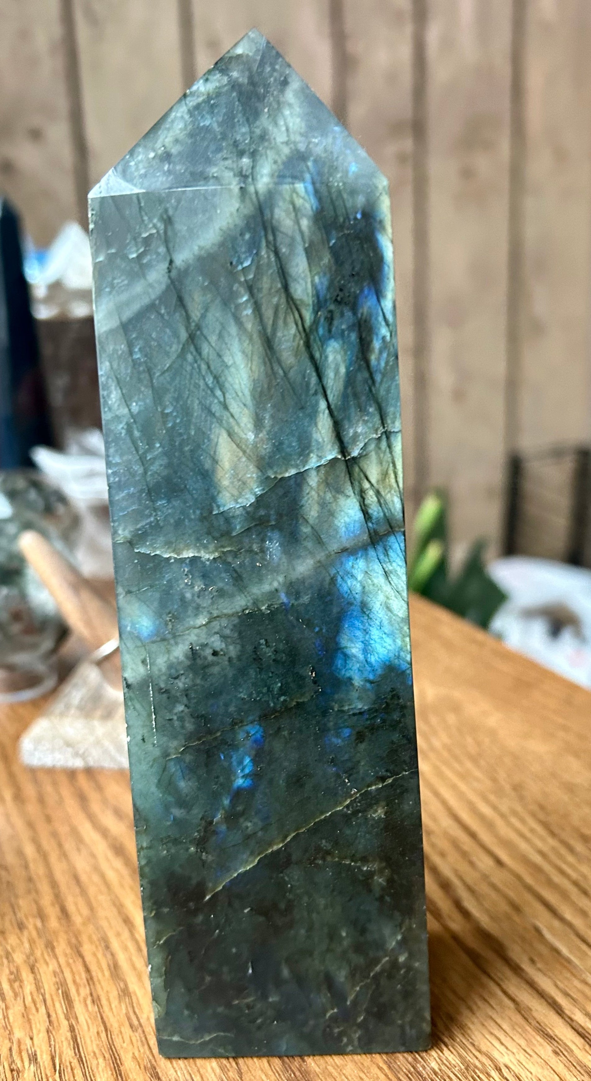 Labradorite crystal tower on a wooden surface with a blurred background