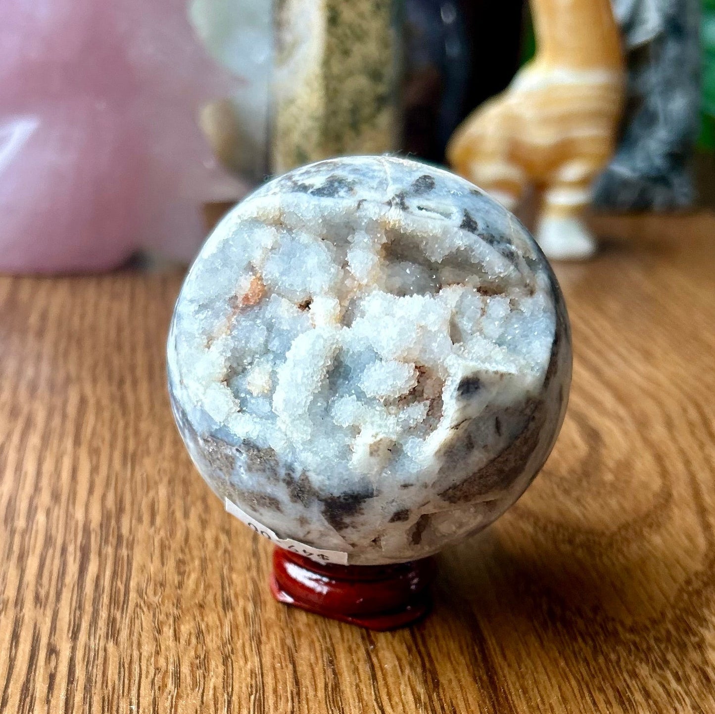 Crystal ball on a wooden surface with decorative items in the background