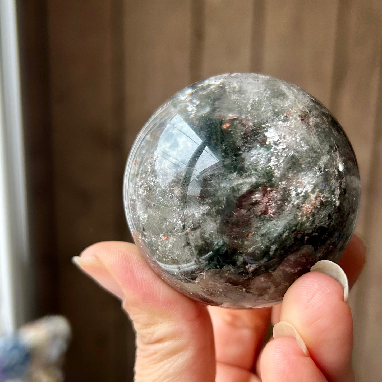 Person holding a large crystal ball with a blurred background