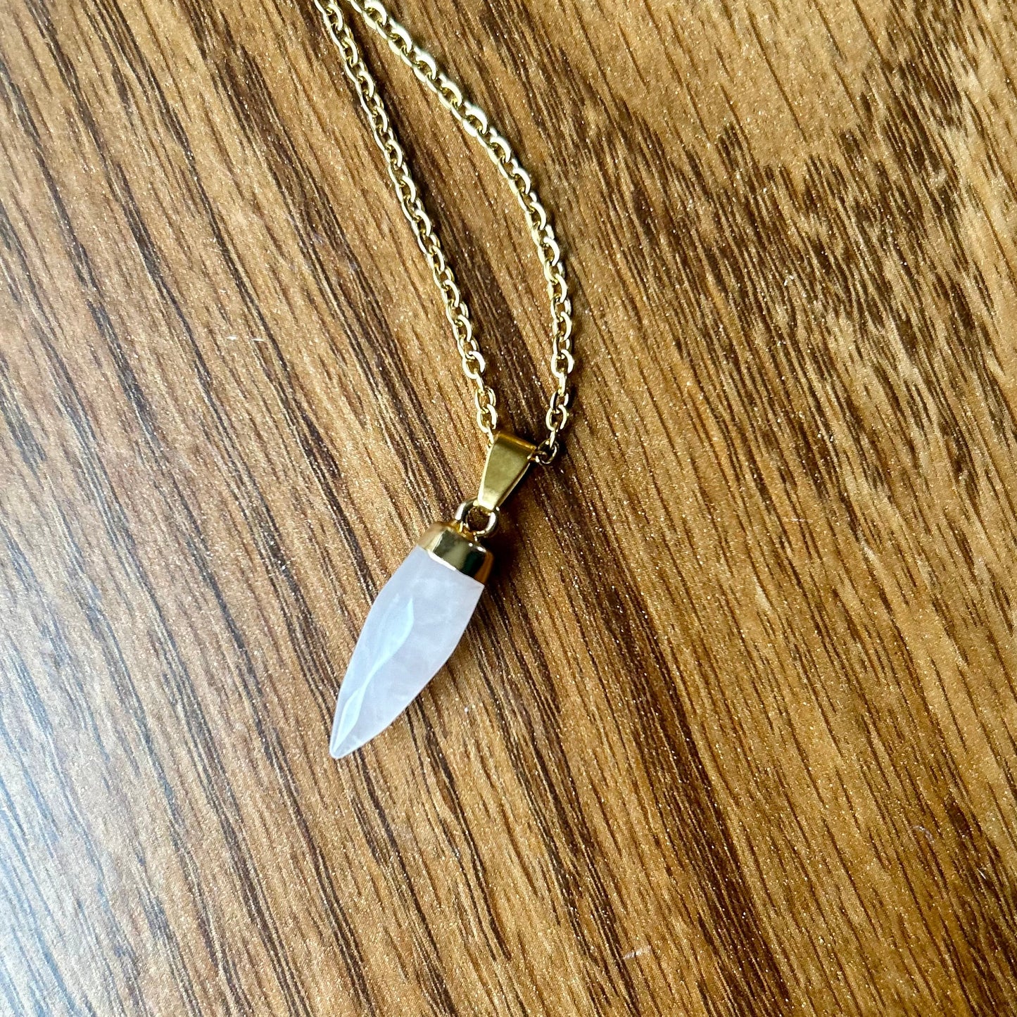 Necklace with a clear stone pendant on a wooden surface