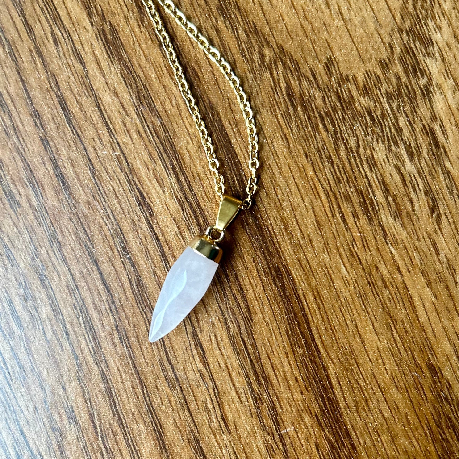 Necklace with a clear stone pendant on a wooden surface