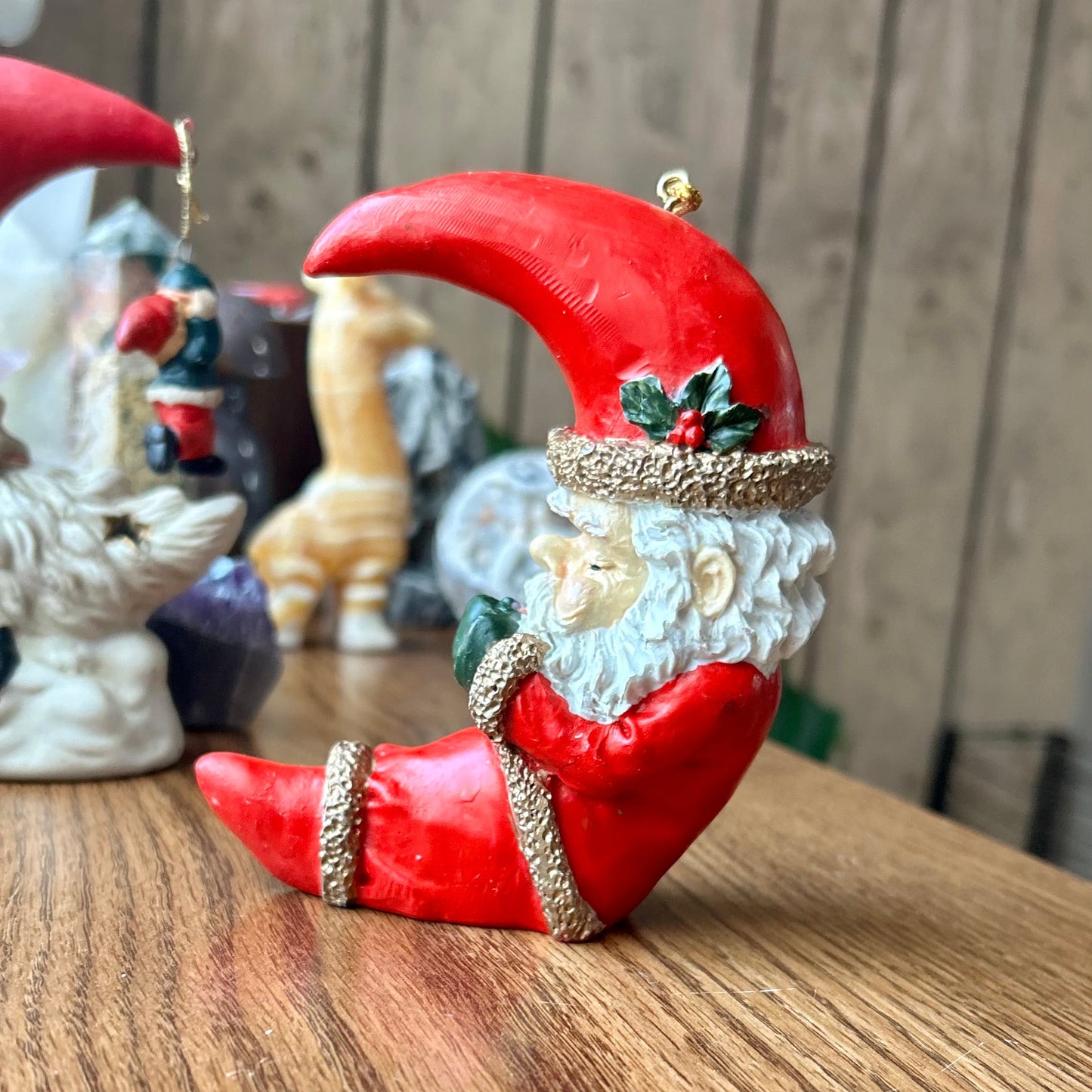 Red crescent moon-shaped ornament with a face on a wooden surface