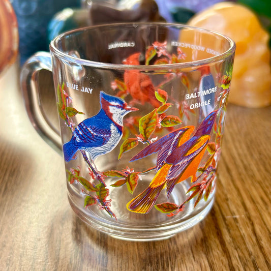 Clear mug with bird design on a wooden surface