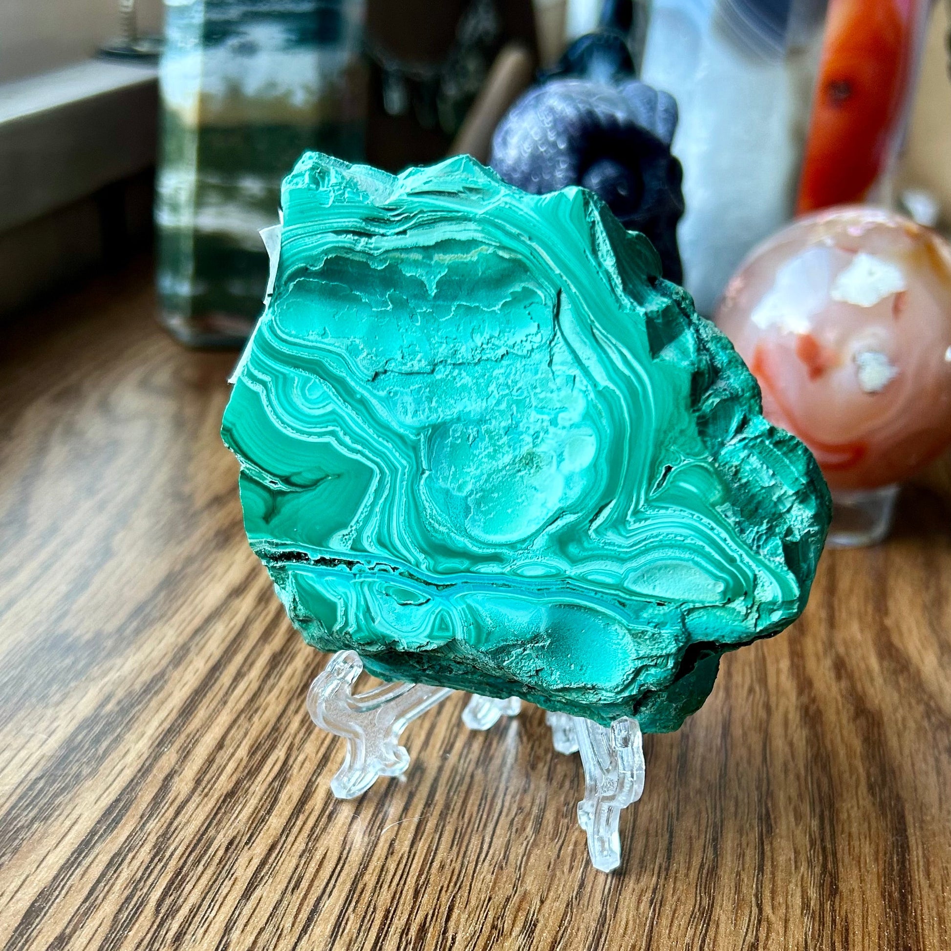 Green mineral specimen on a wooden surface with blurred background
