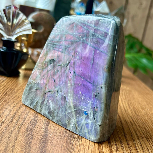 Multicolored crystal on a wooden surface with blurred background