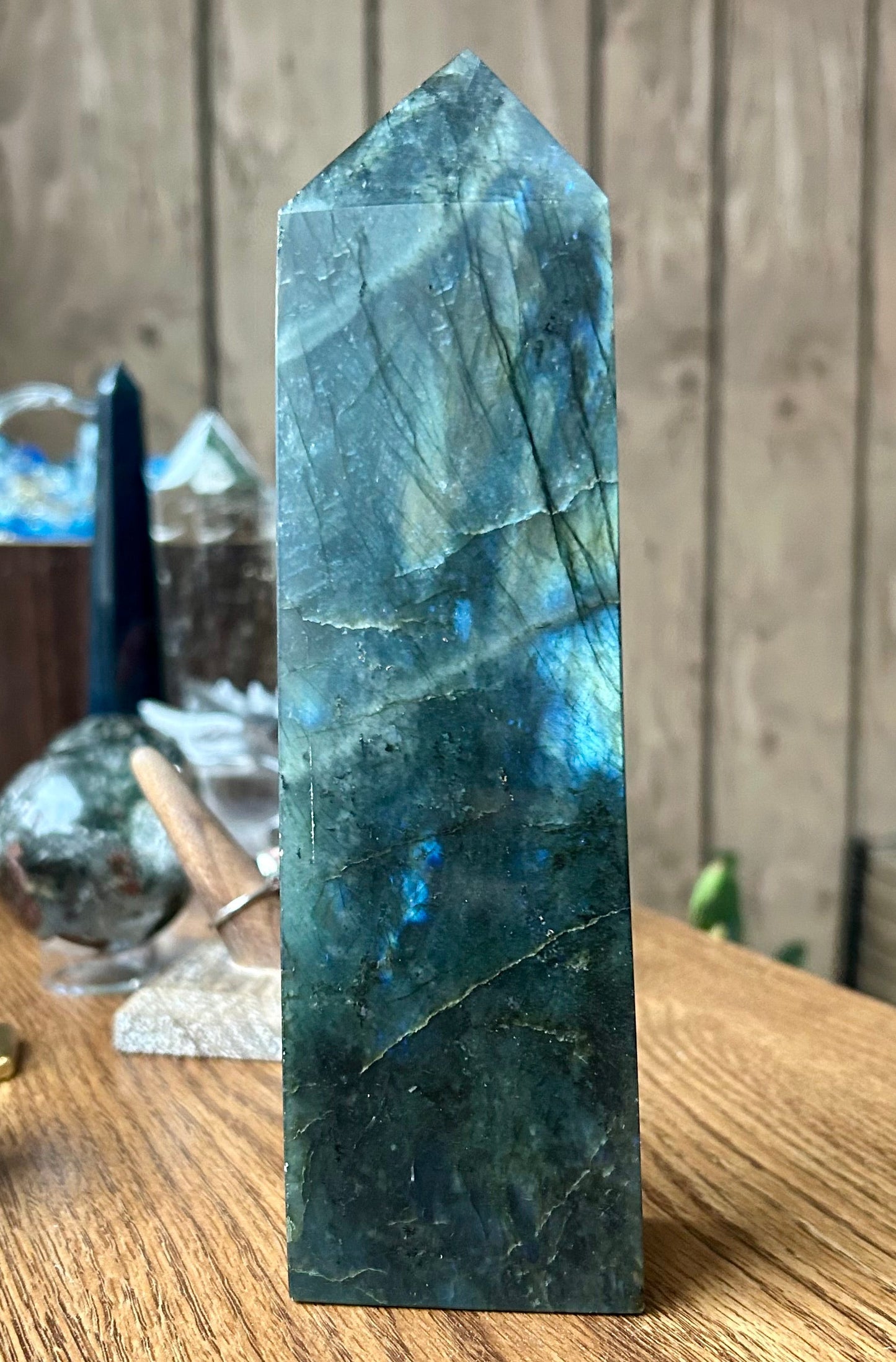 Green crystal tower on a wooden surface with a wooden panel background
