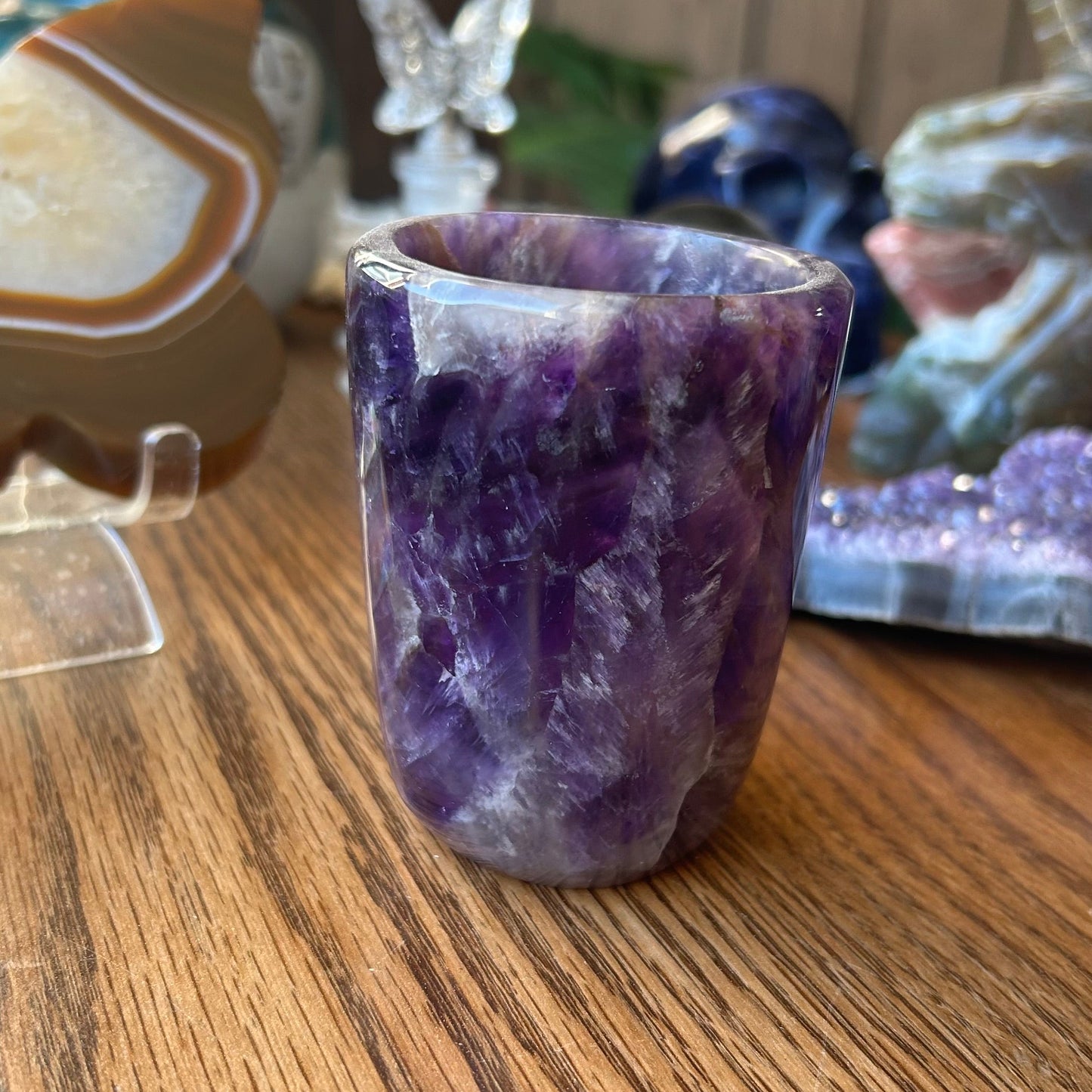 Amethyst crystal vase on a wooden surface with blurred background