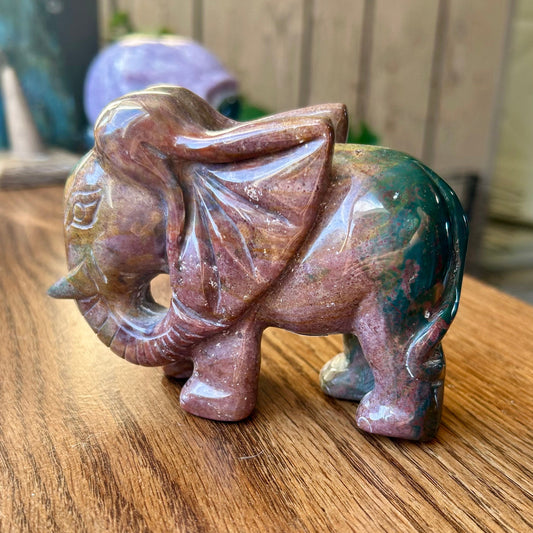 Polychrome stone elephant figurine on a wooden surface