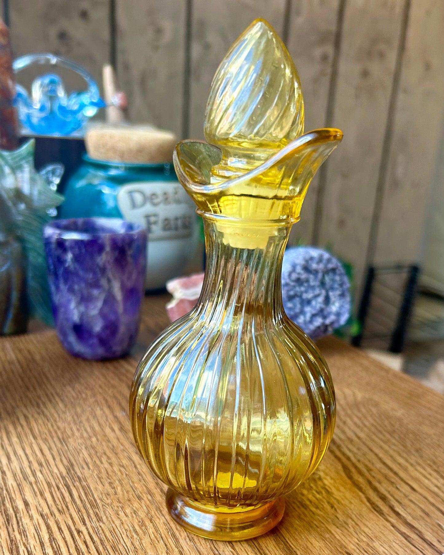 Yellow glass carafe on a wooden surface with blurred background