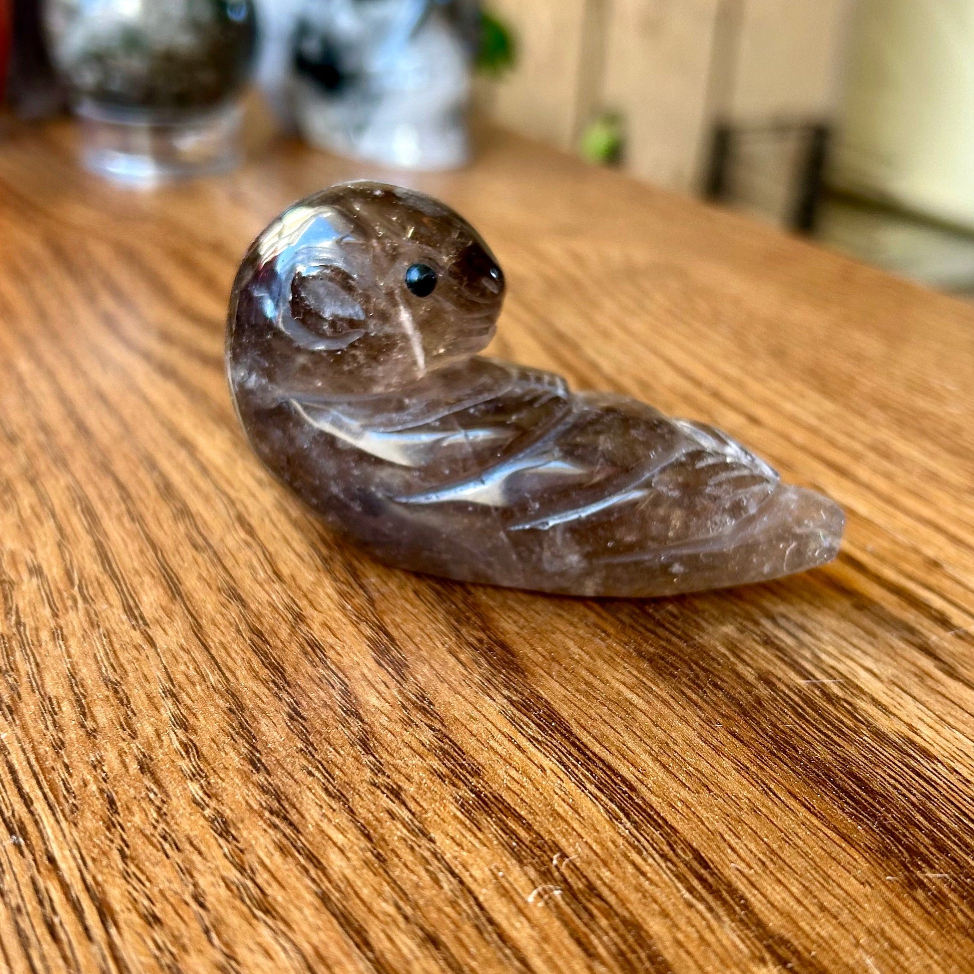 Carved stone snake on a wooden surface with a blurred background
