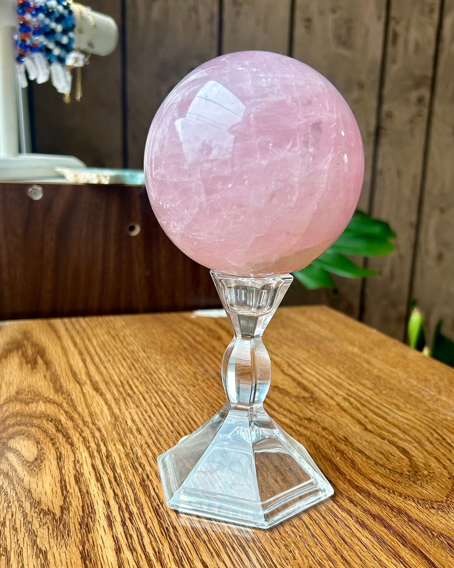 Pink crystal ball on a wooden surface with a blurred background