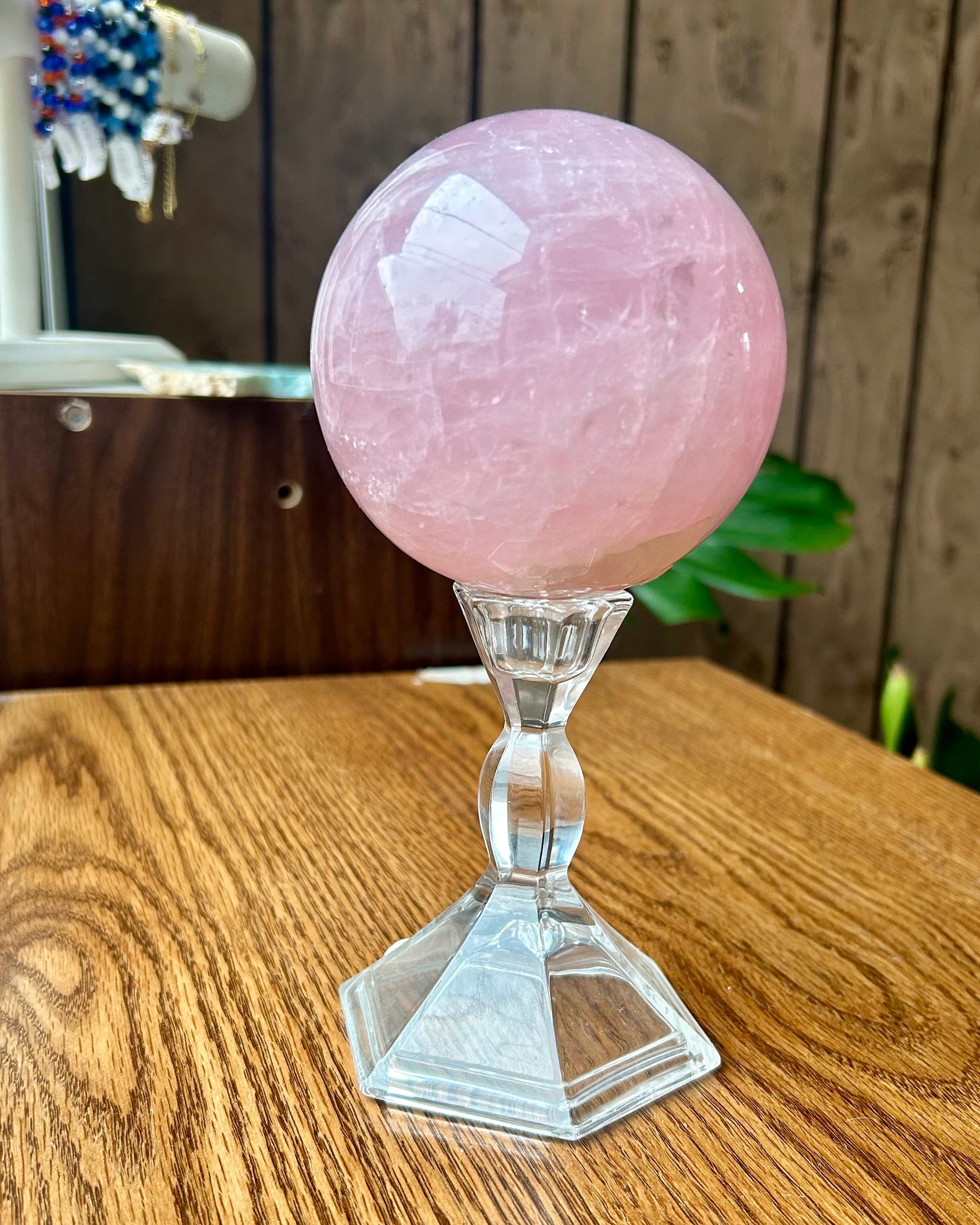 Pink crystal ball on a wooden surface with a blurred background
