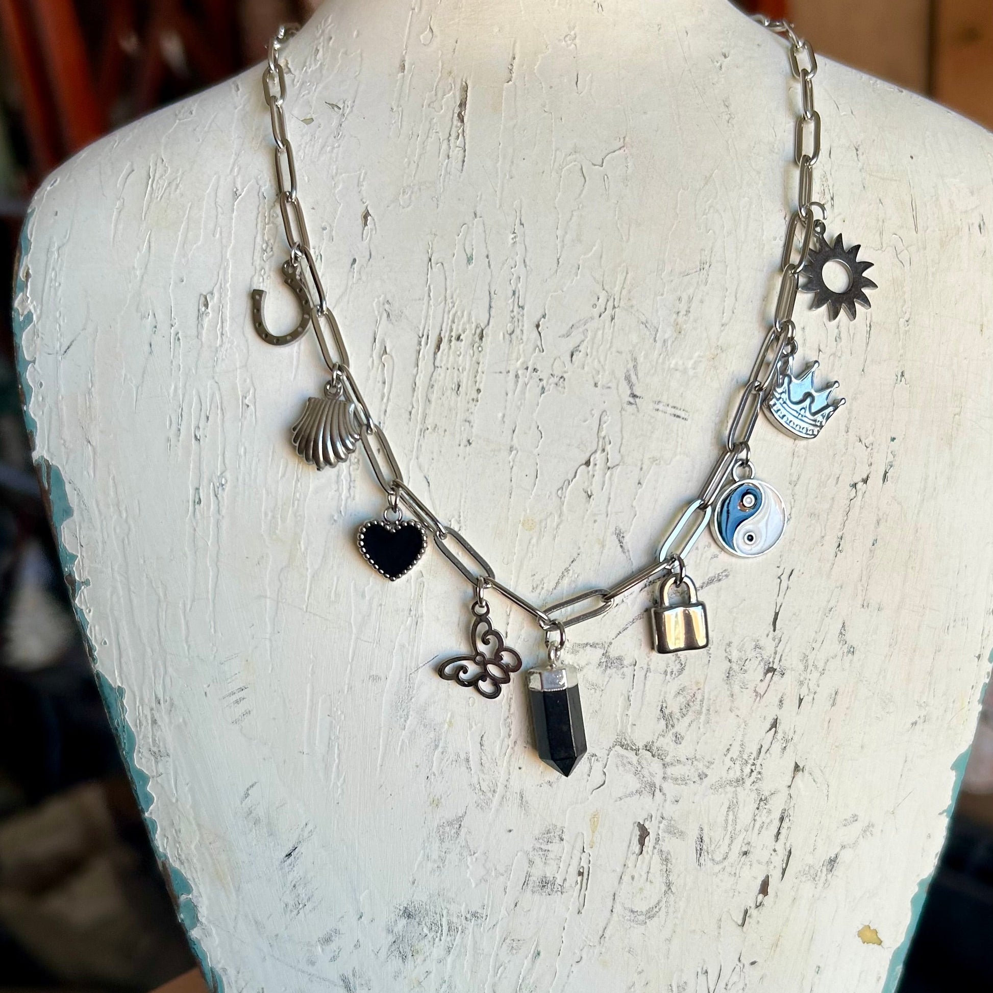 Necklace with various charms on a mannequin bust