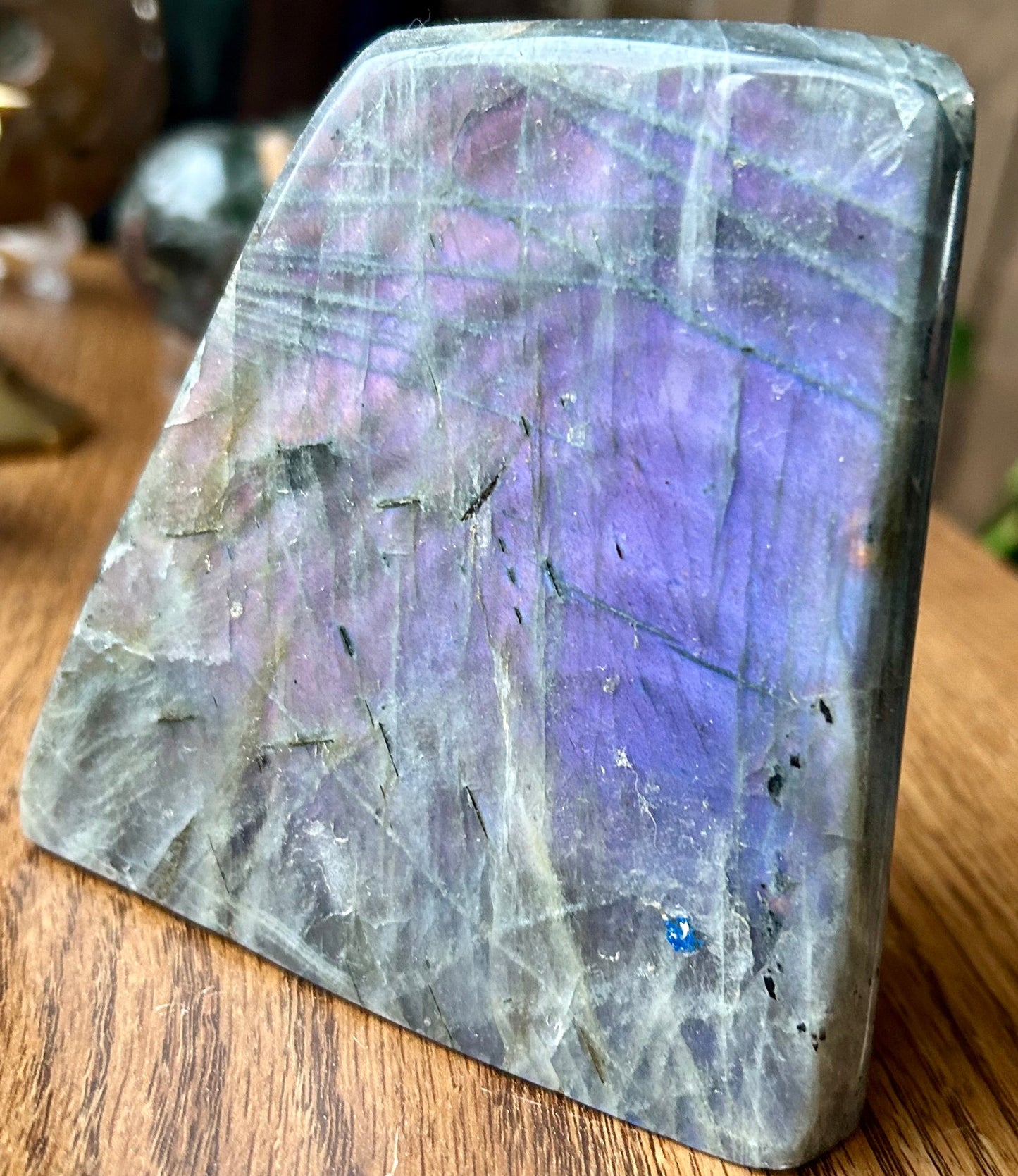 Polished stone with purple and blue hues on a wooden surface