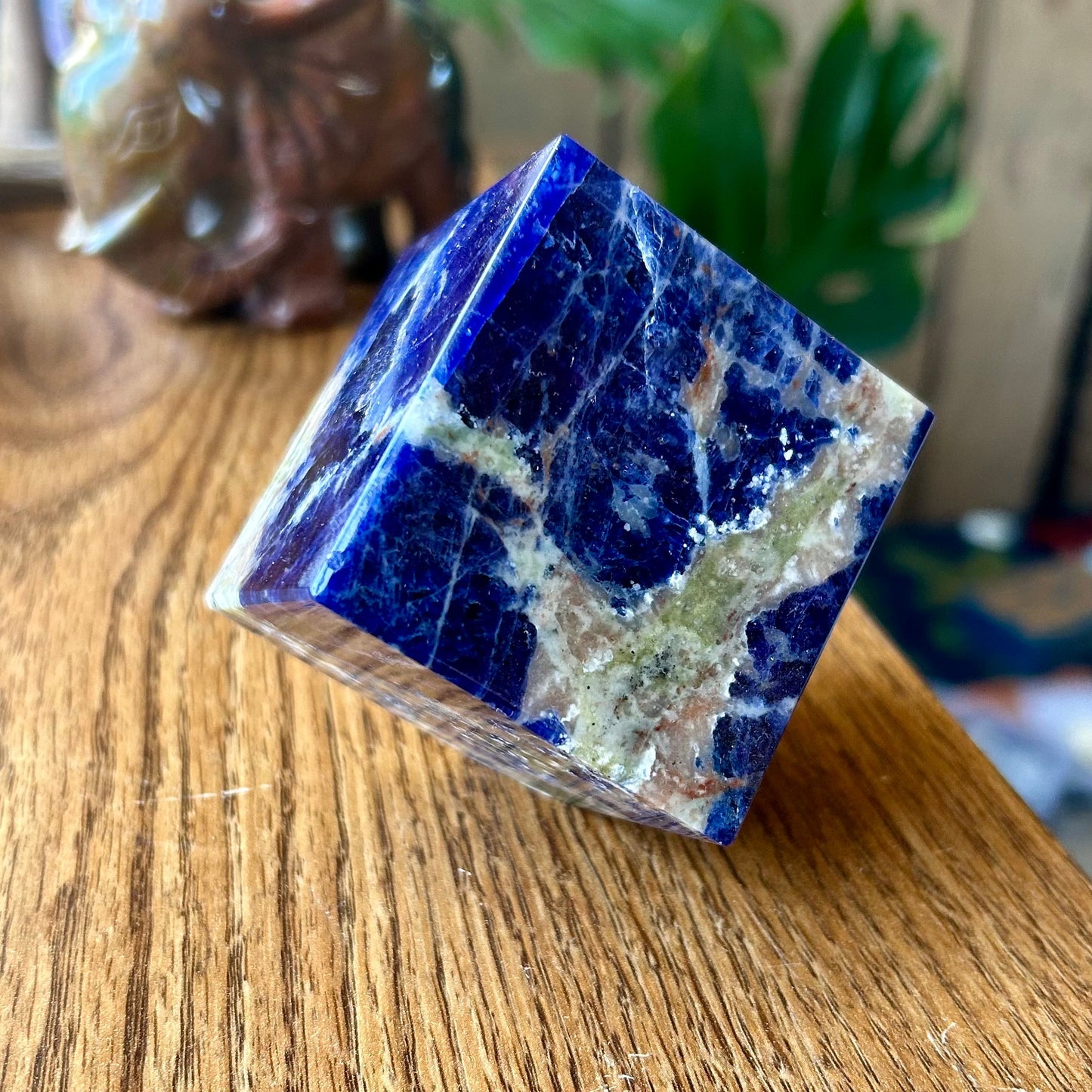 Blue crystal pyramid on a wooden surface with a blurred background